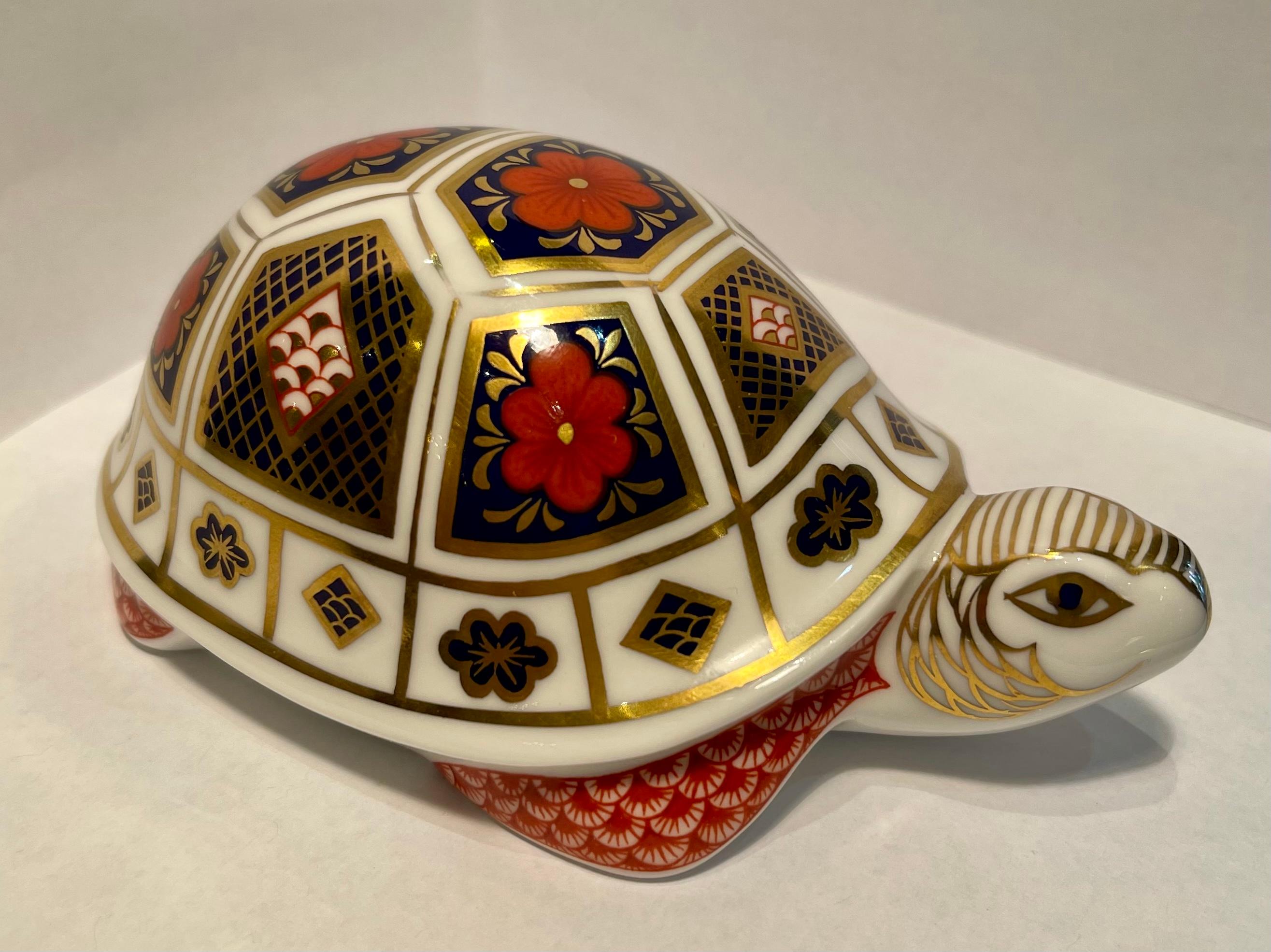 Very collectible, hand-made and hand-painted in England, retired Royal Crown Derby fine bone china turtle or tortoise figurine or paperweight. The turtle is richly decorated in rust, cobalt blue and accented with 22k gold in the famous Japonisme