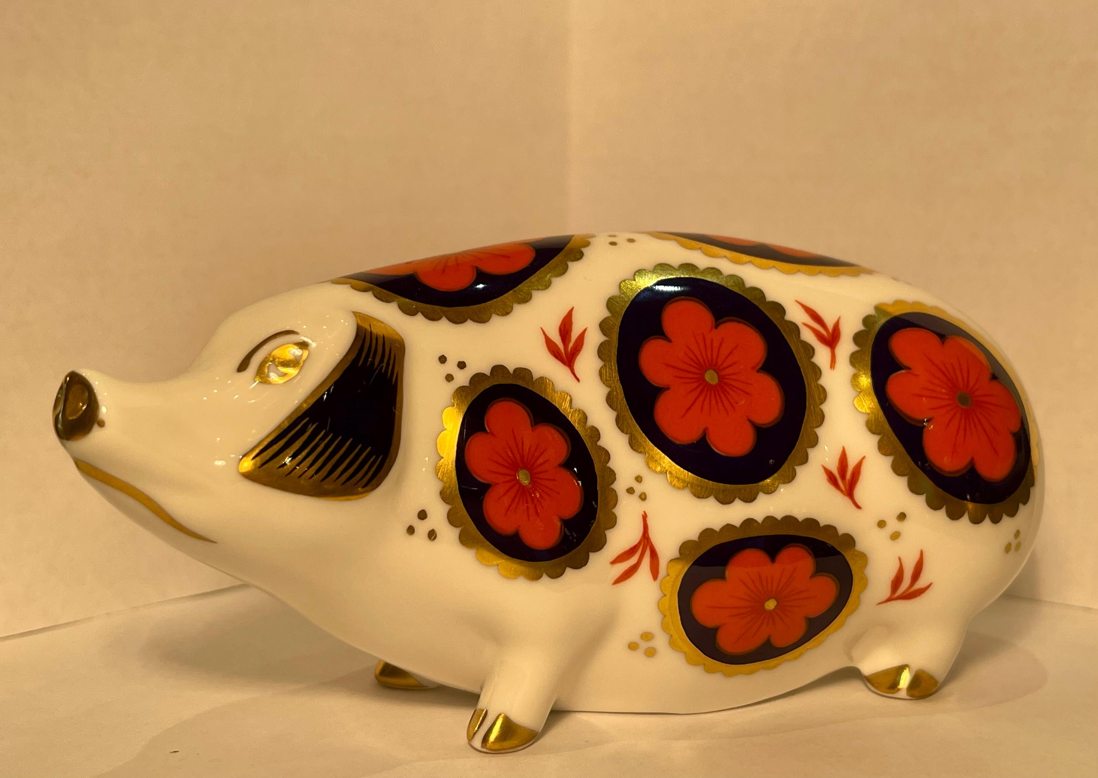 Very collectible, hand-made and hand-painted in England, retired Royal Crown Derby fine bone china pig figurine or paperweight. The pig is richly decorated in rust, cobalt blue and accented with 22k gold in the famous Japonisme style Imari colors.
