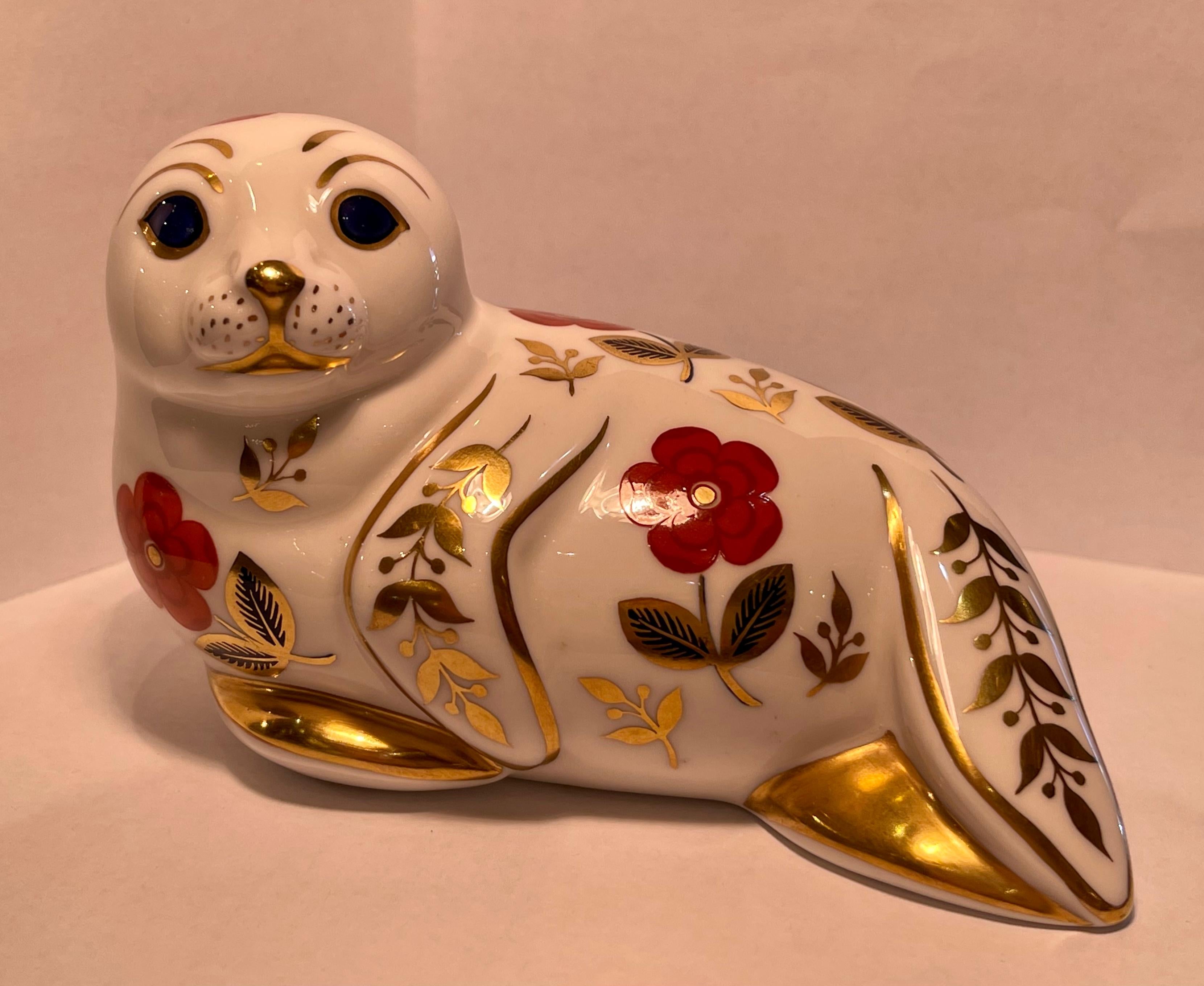 Very collectible, hand-made and hand-painted in England, retired Royal Crown Derby fine bone china seal figurine or paperweight. The seal is richly decorated in rust, cobalt blue and accented with opulent 22k gold in the famous Japonisme style Imari