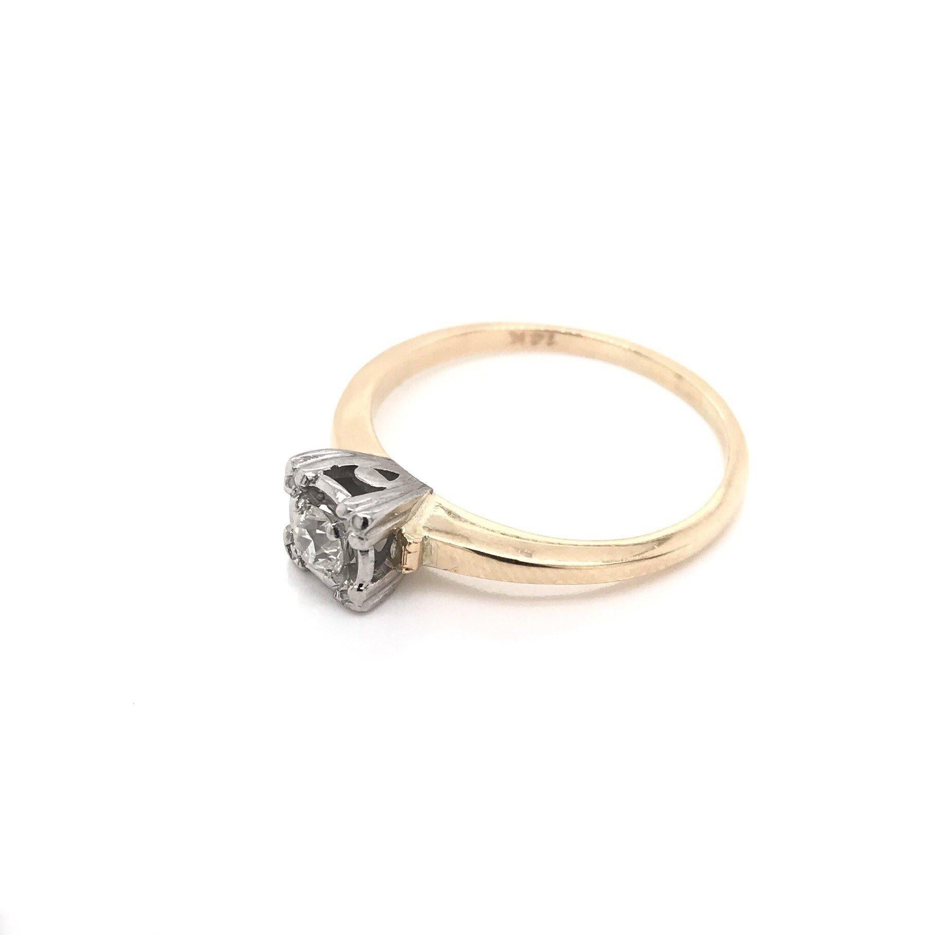 This Mid Century solitaire style ring was crafted sometime during the Retro design period ( 1940-1960 ). The setting is 14k gold with 14k white gold accents. The prong style is often referred to as a fishtail setting, common during this design