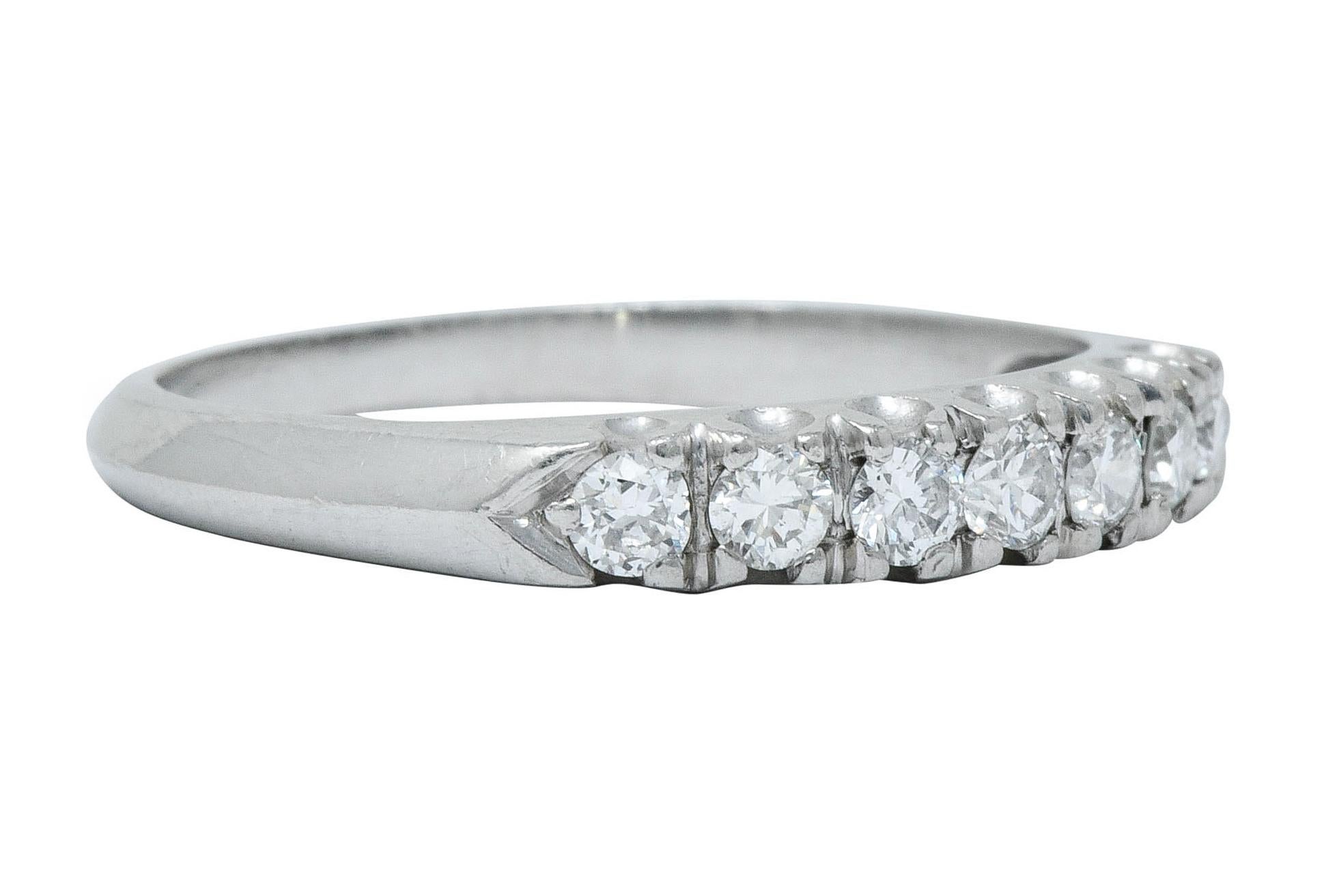 Band style ring set to front with seven round brilliant cut diamonds

Weighing approximately 0.45 carat total with G/H color and VS clarity

Completed by a fishtail style gallery and pointed shoulders with a knife edged shank

Stamped for