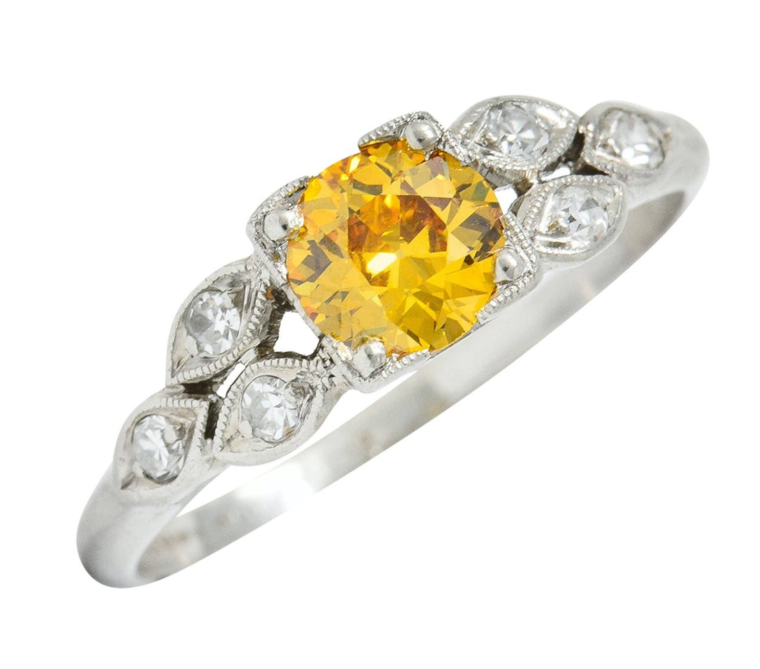 Retro mounting centers an old European cut fancy colored diamond weighing 0.47 carat

With natural fancy intense orange-yellow color and VS clarity

Set in a square form head and flanked by navette form shoulders

Accented by single cut diamonds