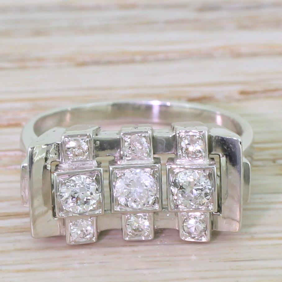 A retro diamond dress ring of real style. This beautiful ring features three old European cut diamonds which are box set within a pierced, concave head, with each of the three main stones is flanked to the top and the bottom by eight-cut diamonds.