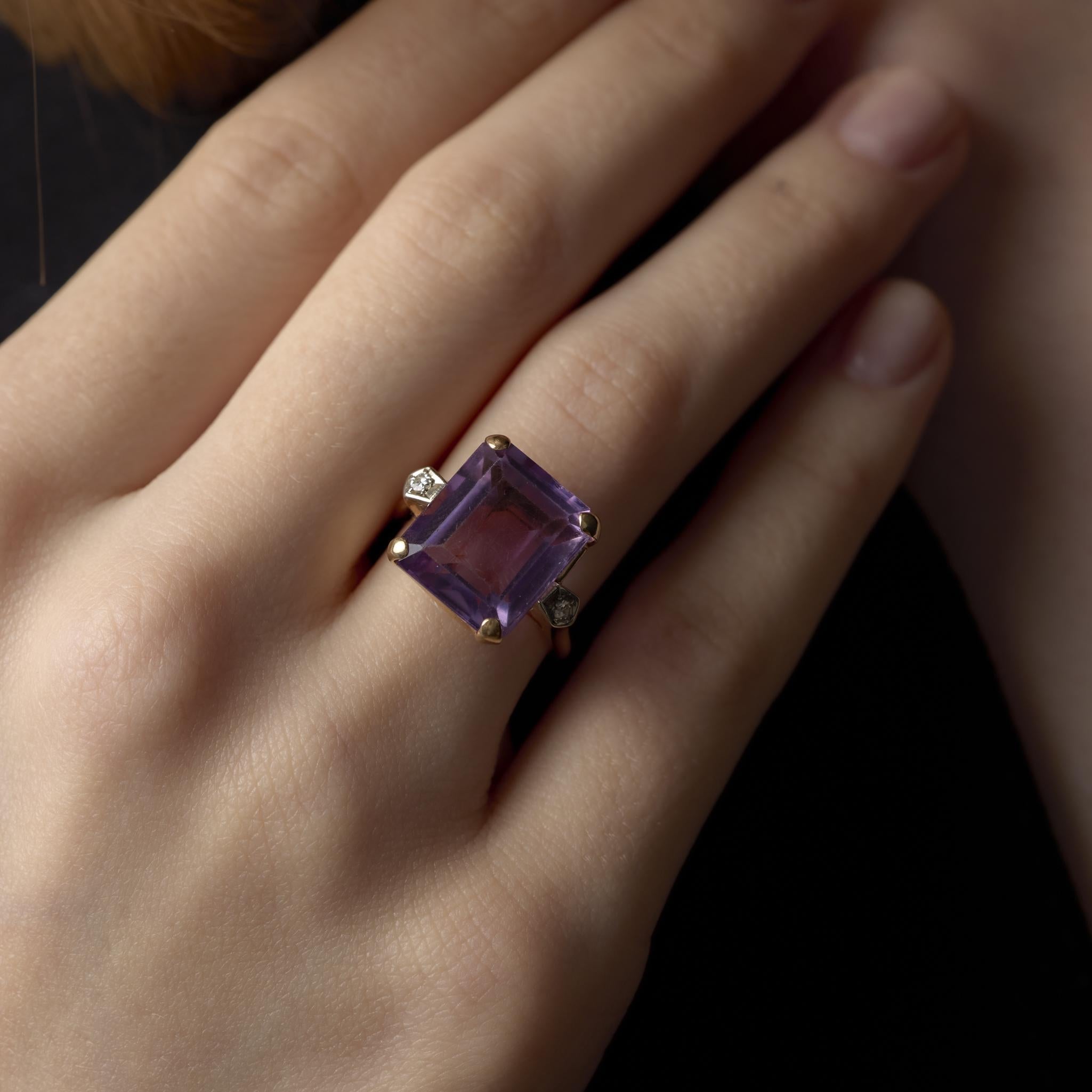 Cette bague rétro des années 1940 brille avec une améthyste de 10,20 carats de taille émeraude encadrée de délicats accents de diamants, magnifiquement sertis dans de l'or jaune et blanc contrastant.