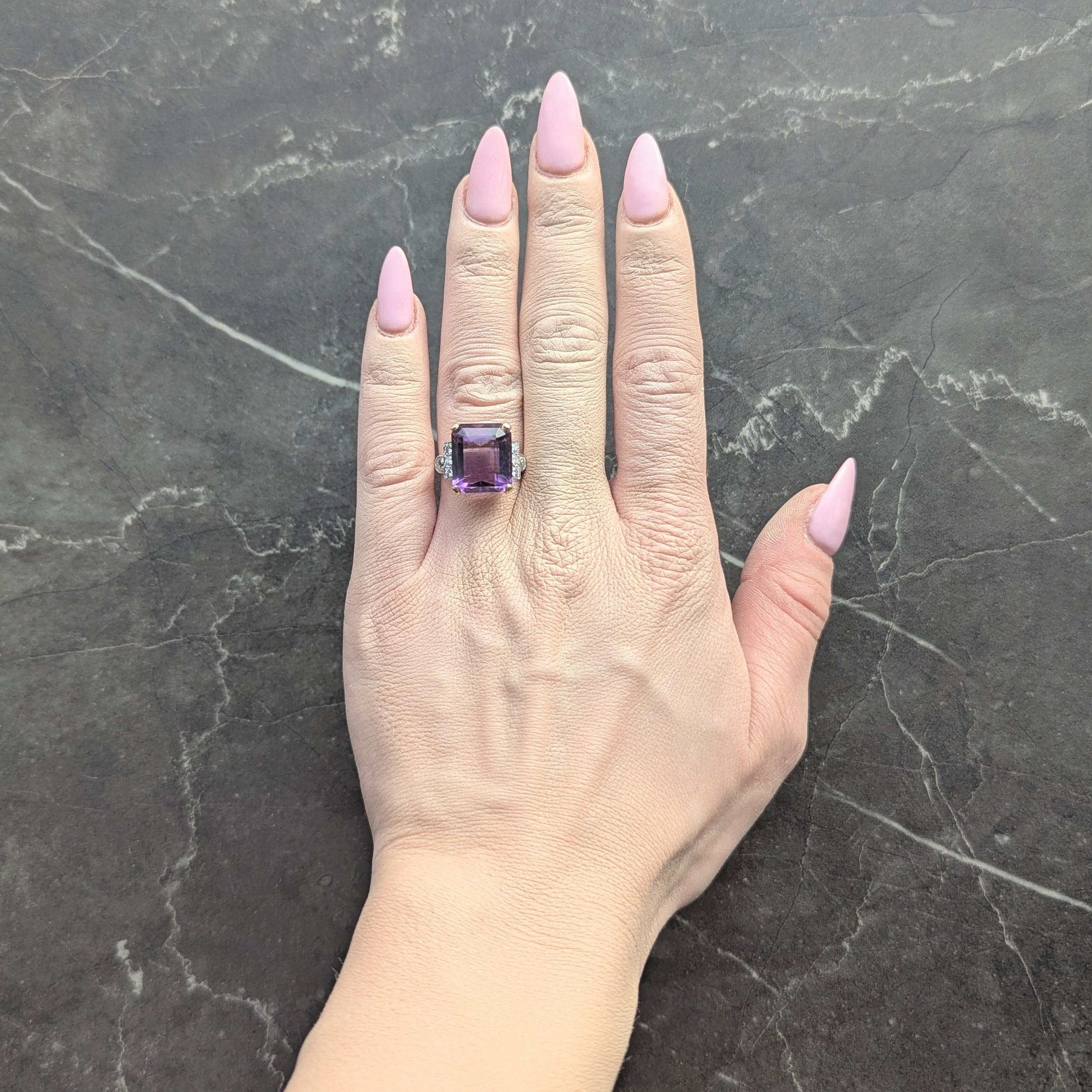 Centering an emerald cut amethyst weighing approximately 9.74 carats
Transparent medium purple in color - prong set in basket
Flanked by rows of bead set transitional cut diamonds
With additional bezel set old European cut diamonds
Weighing
