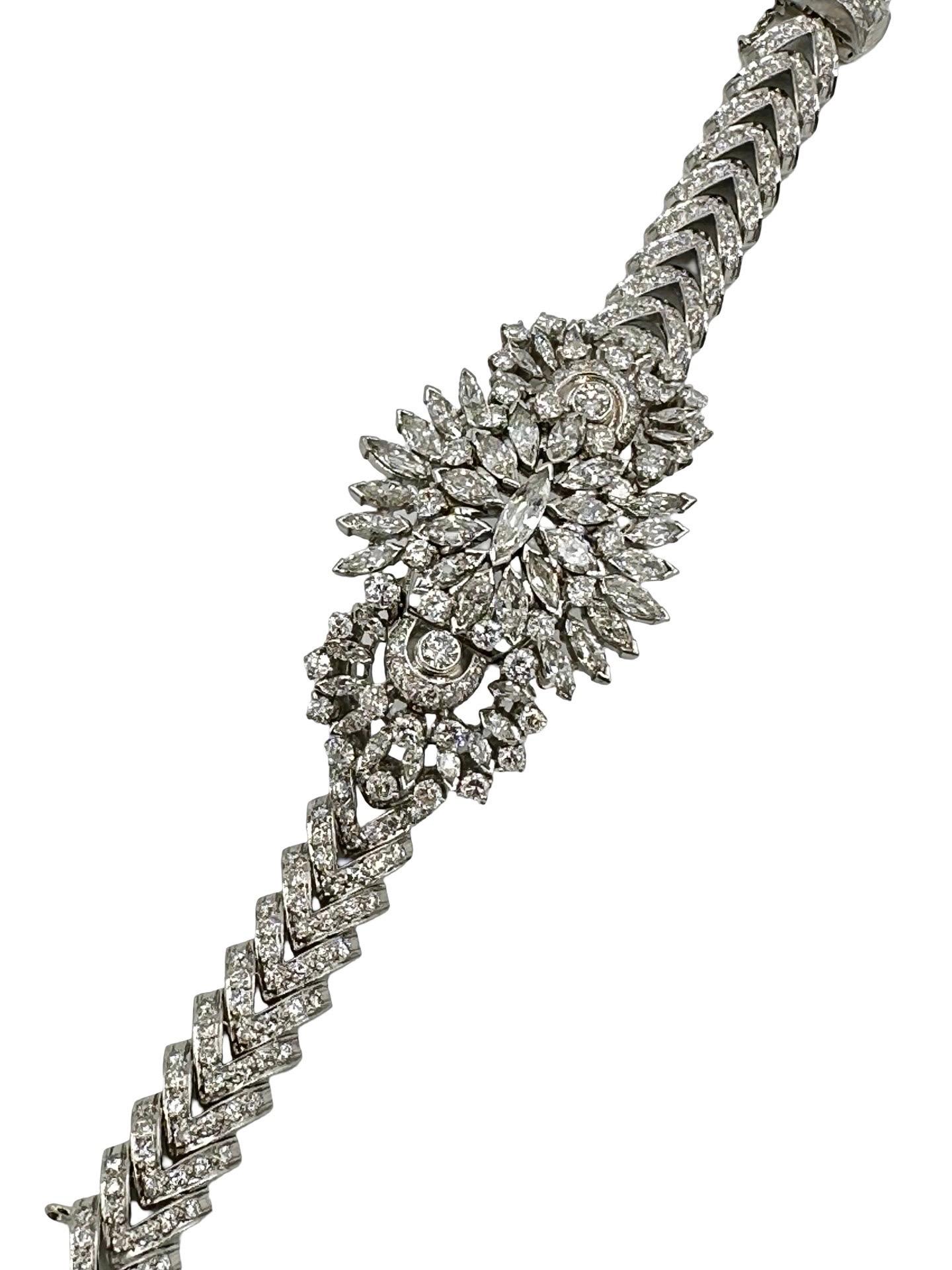 Ce bracelet éblouissant de l'ère rétro présente un design audacieux et glamour, magistralement réalisé en platine et serti d'environ 10,72 carats de diamants blancs fins.  La pièce centrale brille de mille feux, avec une grappe de diamants marquise