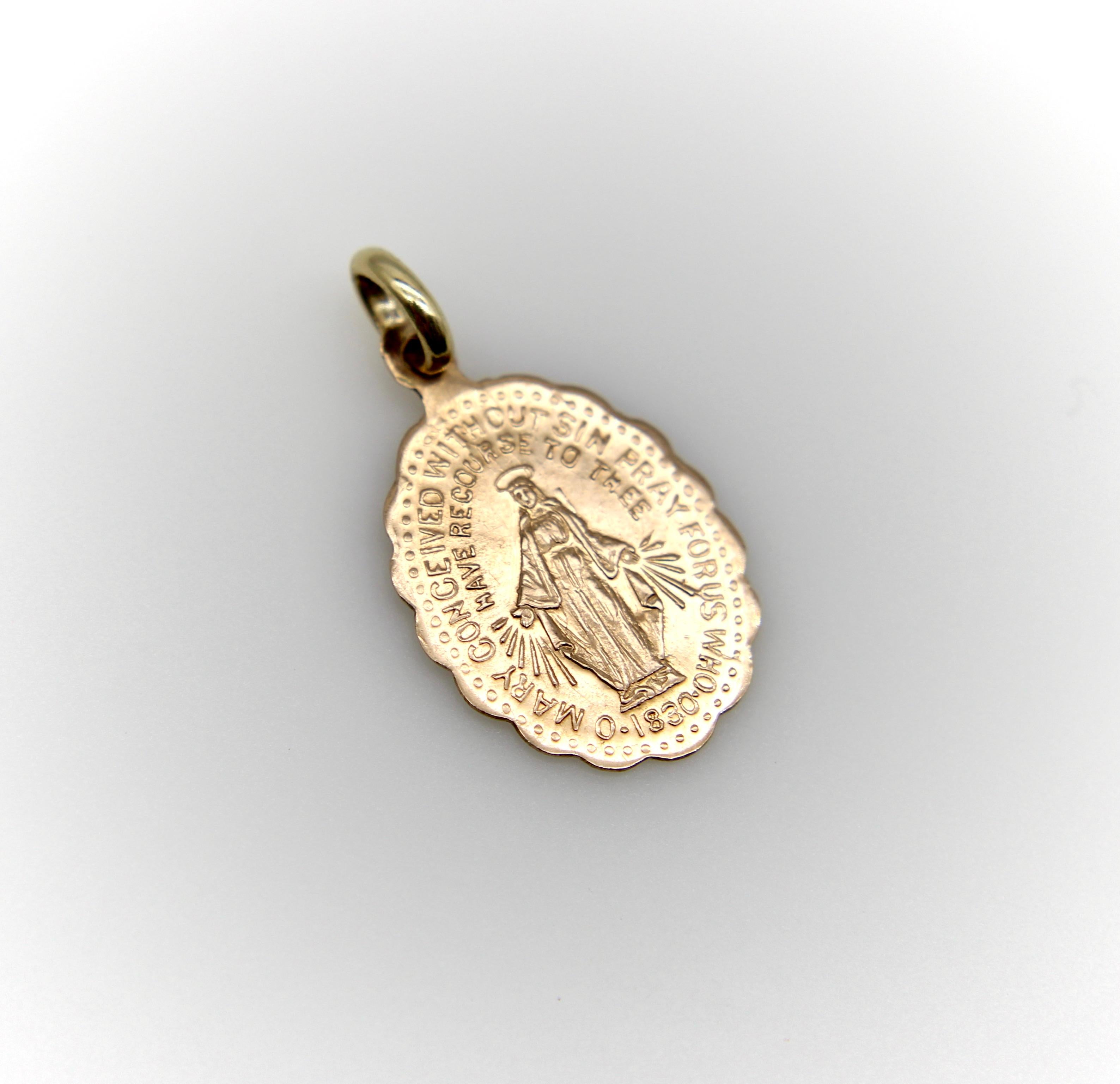 Este amuleto vintage de Santa María de oro de 10 quilates tiene buenos y nítidos detalles y un bonito tono rosado. En el anverso se representa a María con las palabras 
