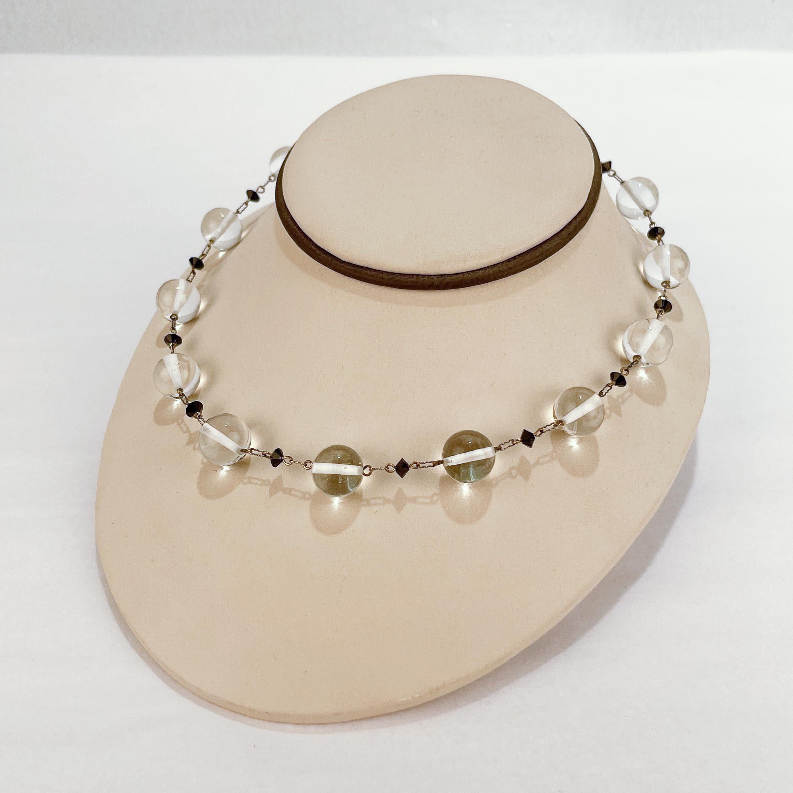 A very fine retro glass bead and sterling silver choker necklace.

With alternating clear 13mm and black faceted glass beads.

Each bead has a sterling bar riveted through its center and is connected to the next bead with a shape silver link.

Very