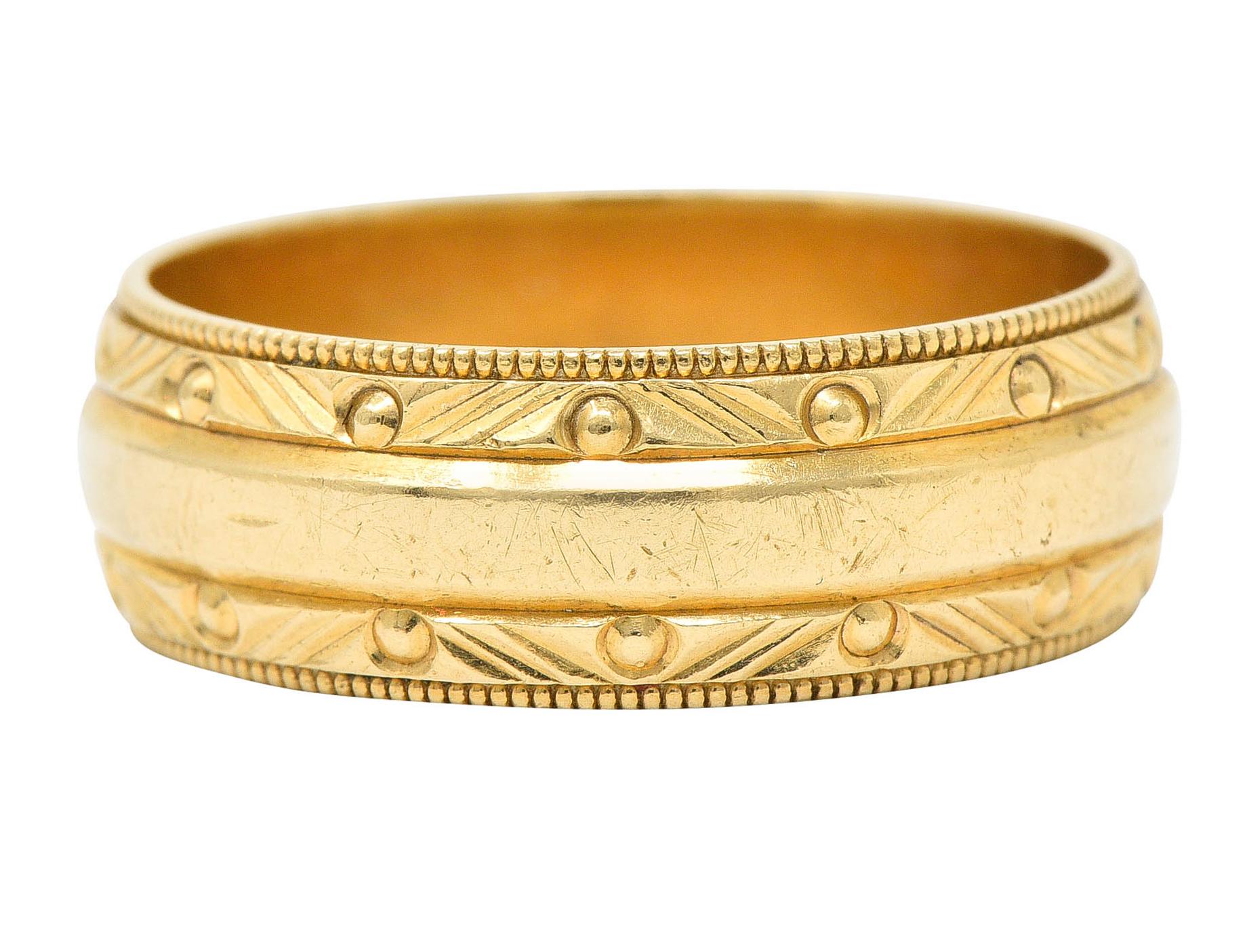 Wide band ring is designed with a smooth center and milgrain edges

With a faceted motif accented by gold beading

Maker's mark and stamped 14K for 14 karat gold

Circa: 1940s

Ring Size: 9 1/2 & sizable

Measures North to South 7.2 mm and sits 1.7