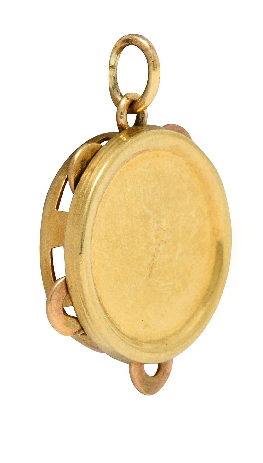 Circular charm is designed as a jingling tambourine

With articulated zills that move and make a slight chime

Completed by a jump ring bale

With maker's mark and stamped 14K for 14 karat gold

Circa: 1940s

Measures: 5/8 x 5/8 inch

Total weight: