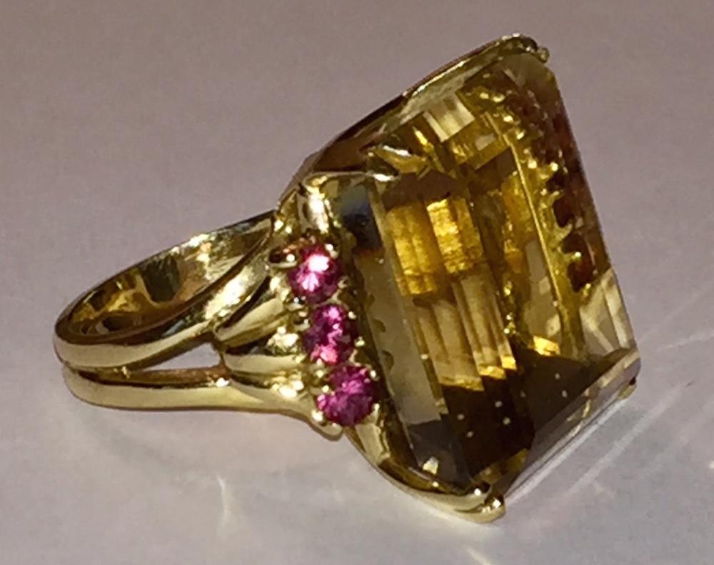 14 karat yellow gold ring with large citrine and pink rubellite side stones. Citrine measures 22 mms by 22 mms. Six rubellite stones are 4mms diameter each. Ring is a size 7. Marked, 14 kt. Weighs, 14.8 grams