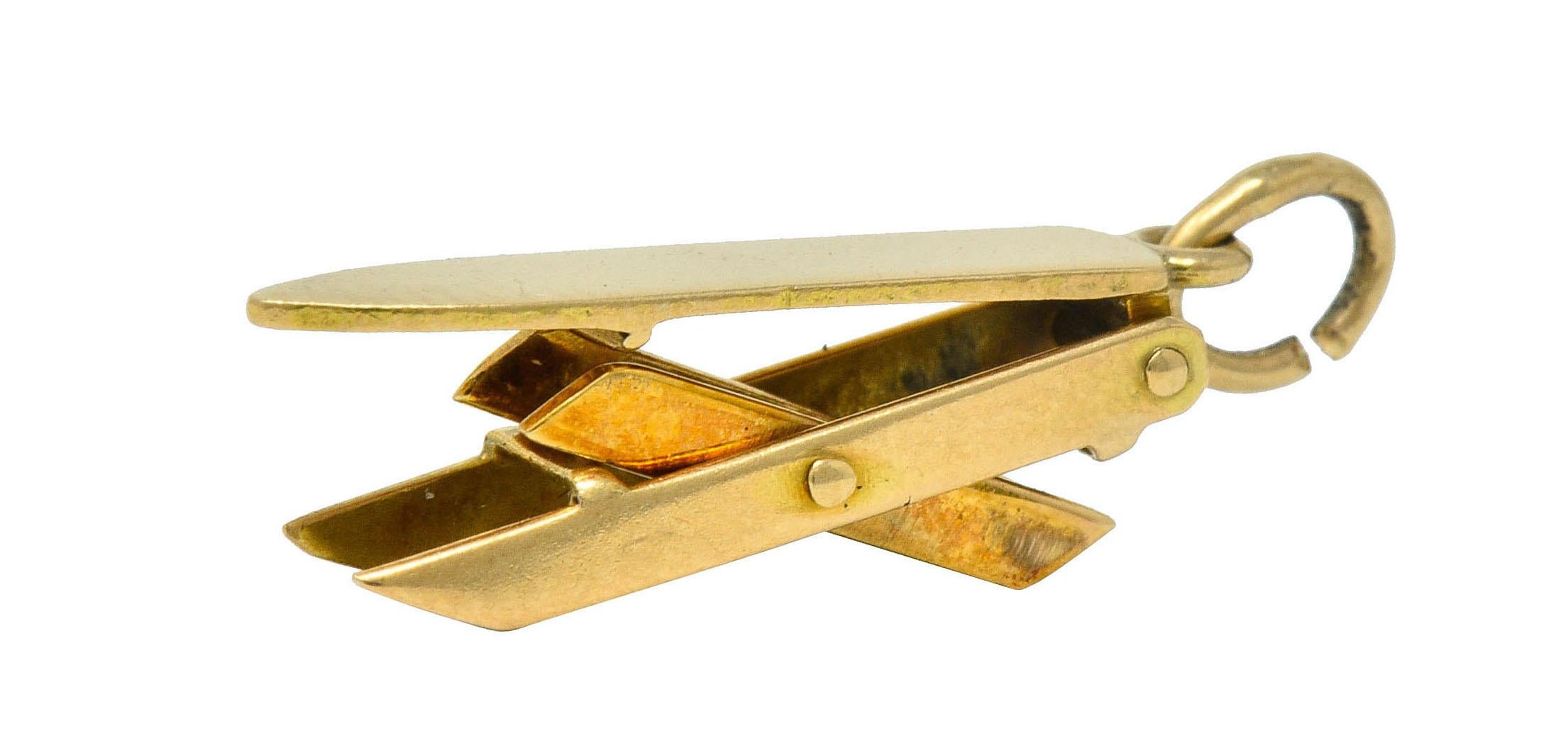 Ironing board charm fully articulates

With base that folds open to support polished gold board

Completed by jump ring bale

Stamped 14K for 14 karat gold

Circa: 1950s

Measures: 3/16 x 7/8 inch

Total weight: 1.2 grams

Functional. Whimsical.