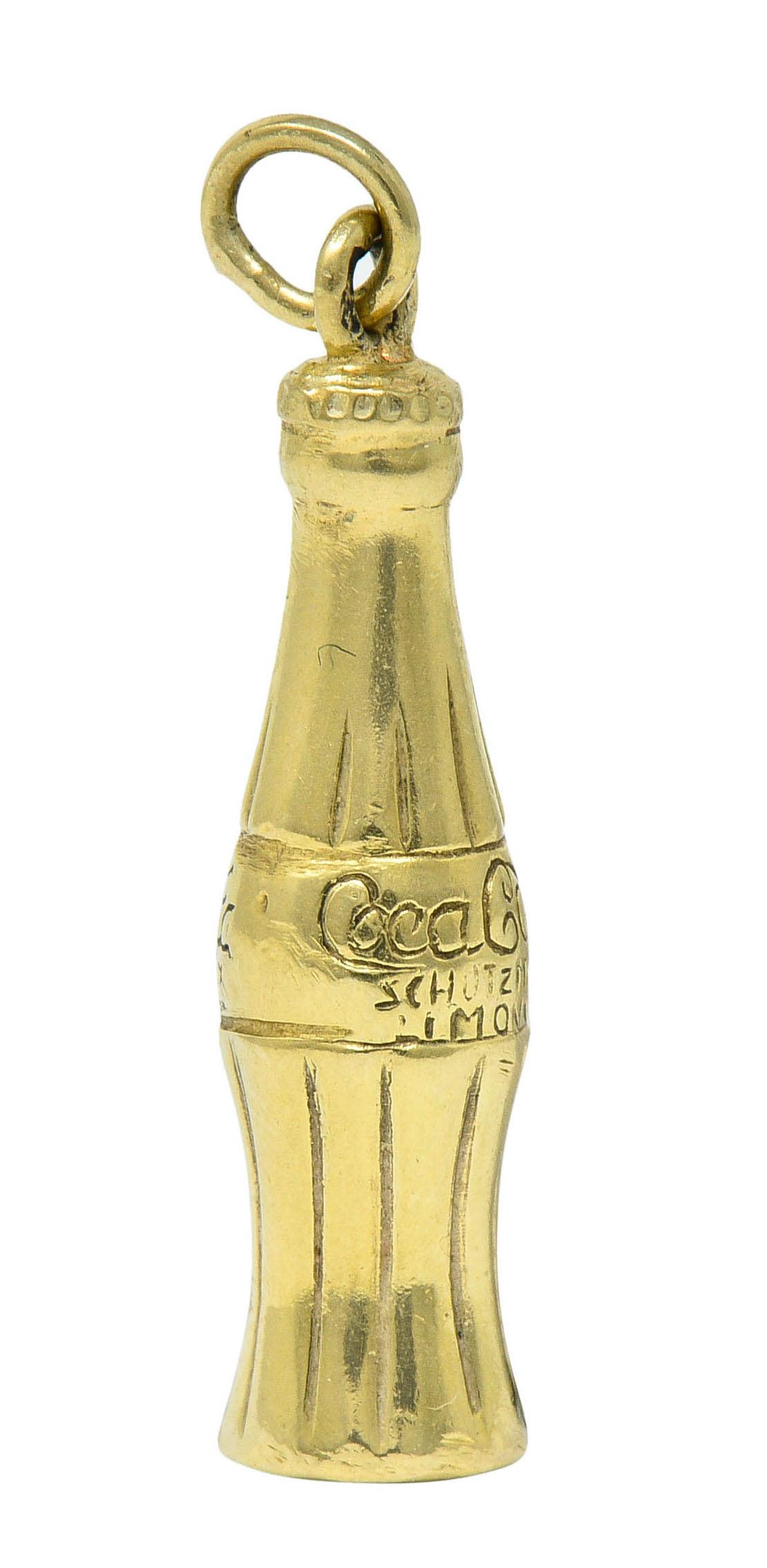 Designed as a vintage Coca Cola bottle with deeply engraved fluting

Label is inscribed 'Coca Cola Schutzmarken'

Completed by jump ring bale

Tested as 14 karat gold

Circa: 1950s

Measures: 1/4 x 1 inch

Total weight: 1.2 grams

Cool. Rare.