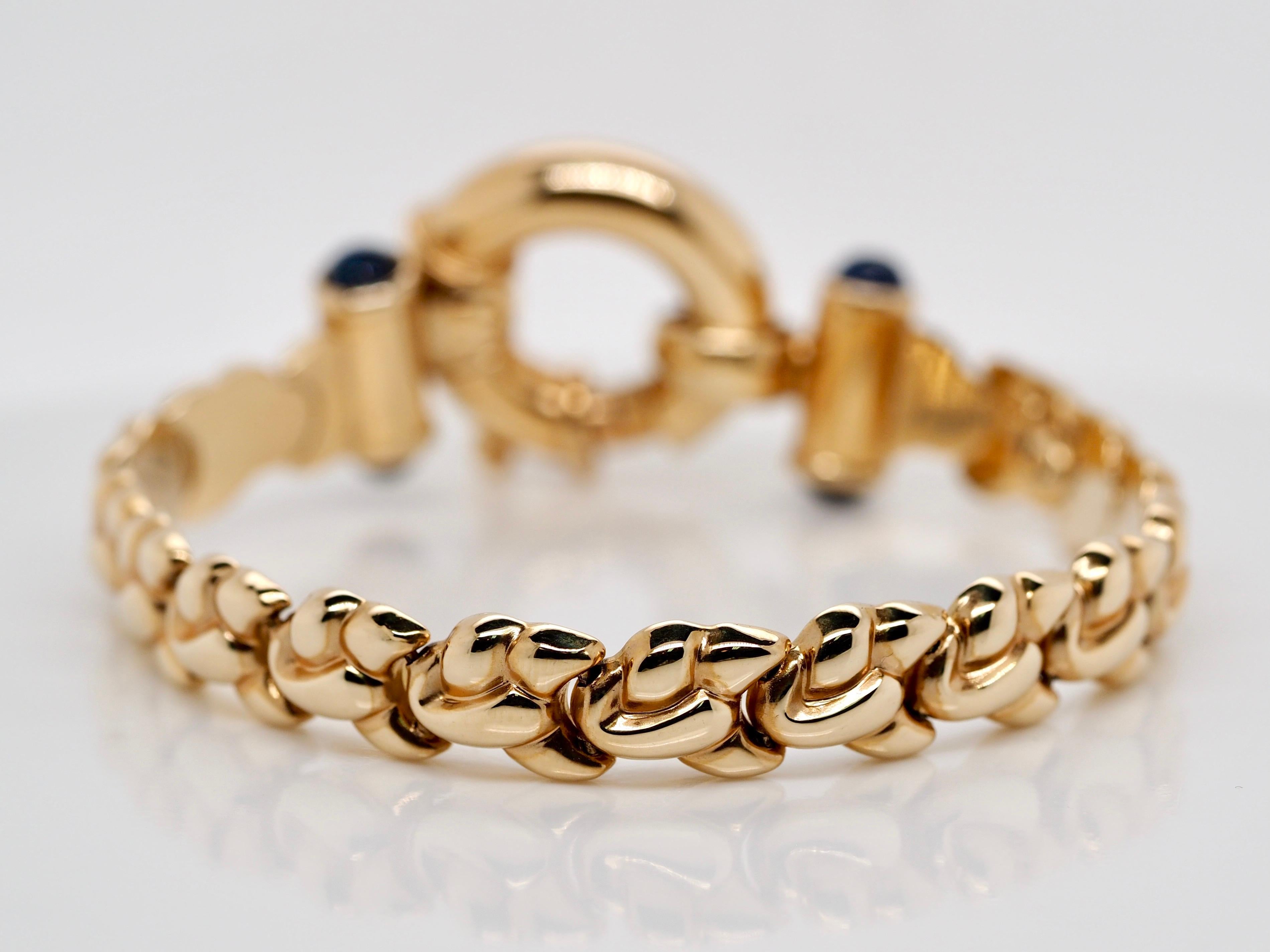 Retro 14 karat Yellow Gold Geometric link Bracelet. It includes a large bolt clasp with a round Cabochon Sapphire on the sides. This stunning vintage Italian piece is in excellent condition and is perfect for any day occasion!

Item Details:
Metal