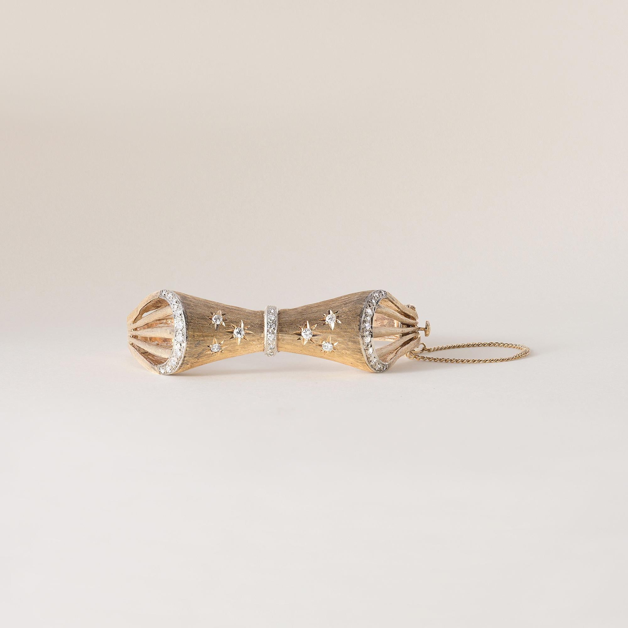 This is a vintage retro bangle in solid 14k gold
featuring flush set diamonds in a bow tie design.
Circa 1940's
Details:
27 single cut diamonds prong in white gold set along the side arches and middle section
6 transitional cut diamonds flush set in