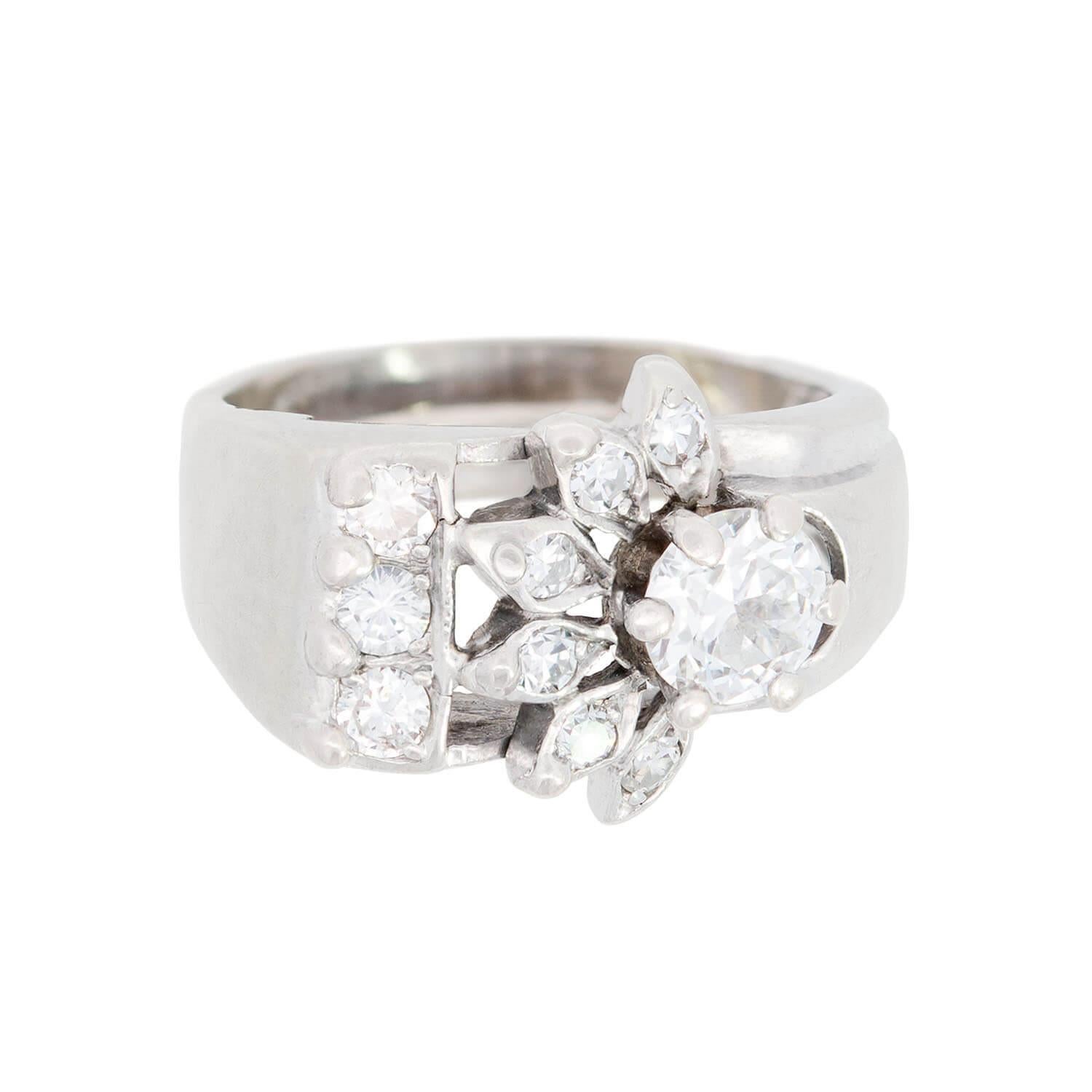 A fabulous diamond ring from the Retro (ca1940s) era! Crafted in platinum, the ring features unique starburst buckle-like design. At the center of the ring is a 0.65 ct, prong-set old European cut diamond with I color and VS2 clarity. The large,