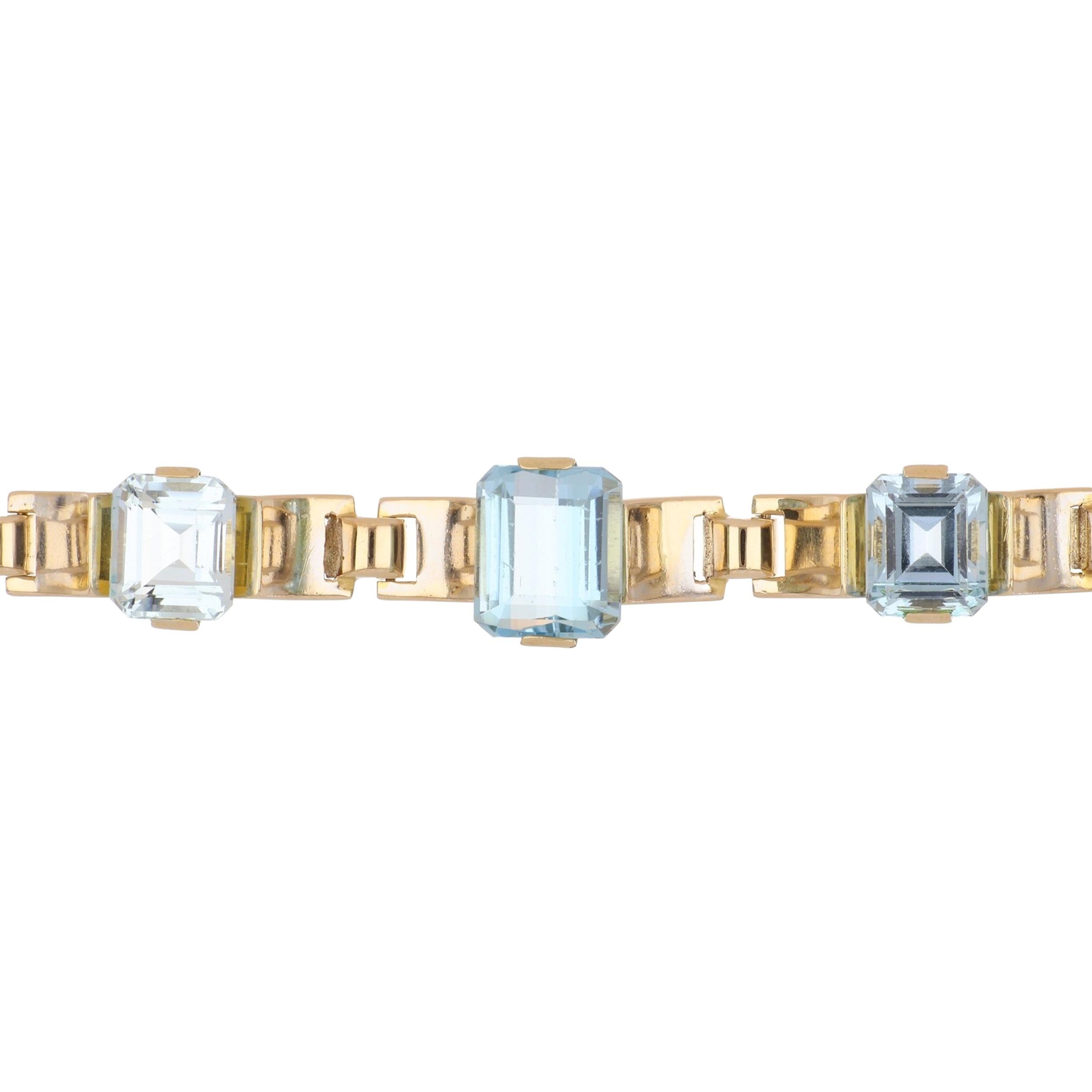 A Retro scalloped link bracelet set with aquamarines in 14K yellow gold. The three emerald-cut aquamarines total 24.93 carats. The bracelet measures 7 inches in length. Circa 1940. 