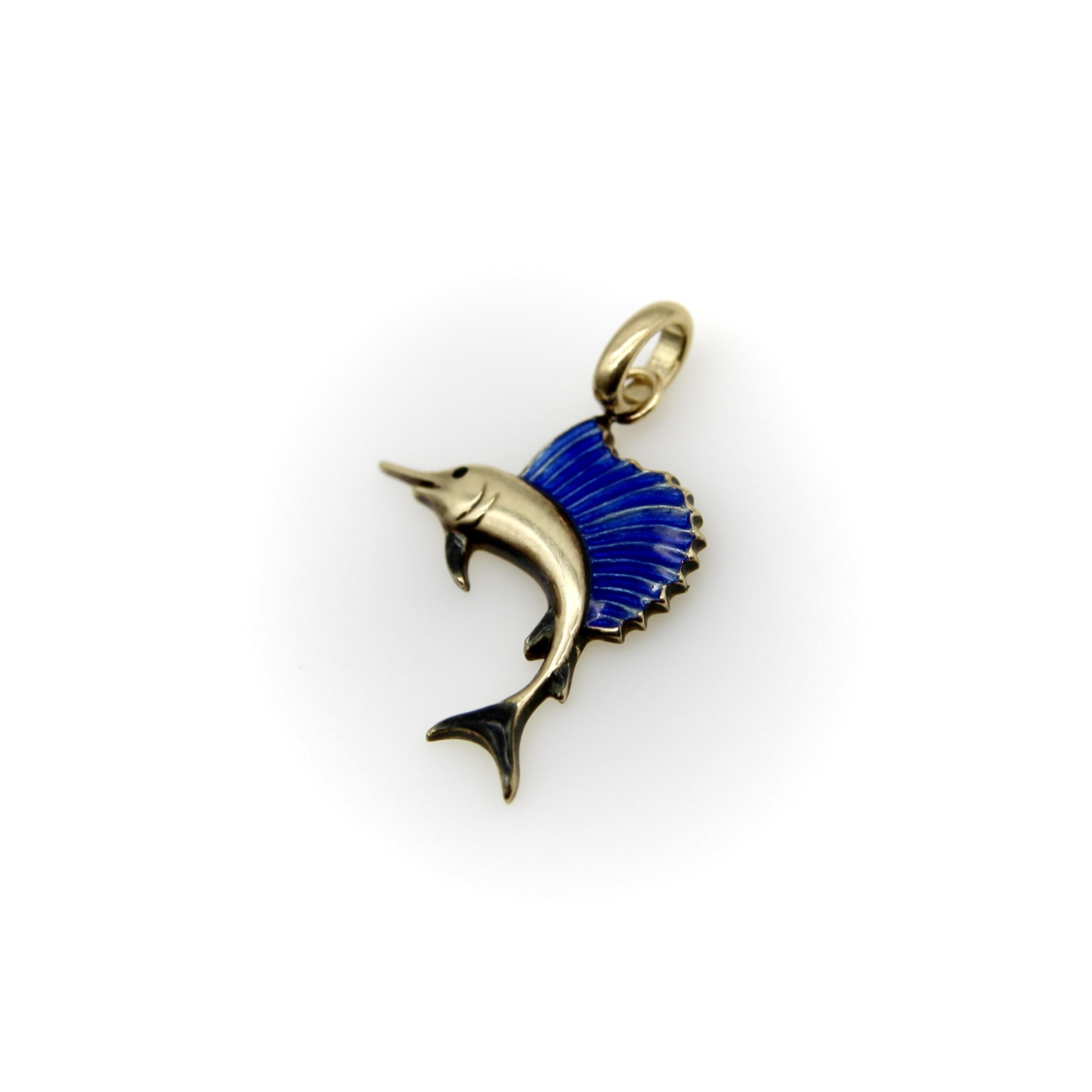 Cette breloque en or 14k représentant un espadon a une forme classique et un magnifique émail bleu sur les nageoires. L'émail bleu est suffisamment transparent pour que l'on puisse voir la texture de l'or en dessous, ce qui donne à la nageoire