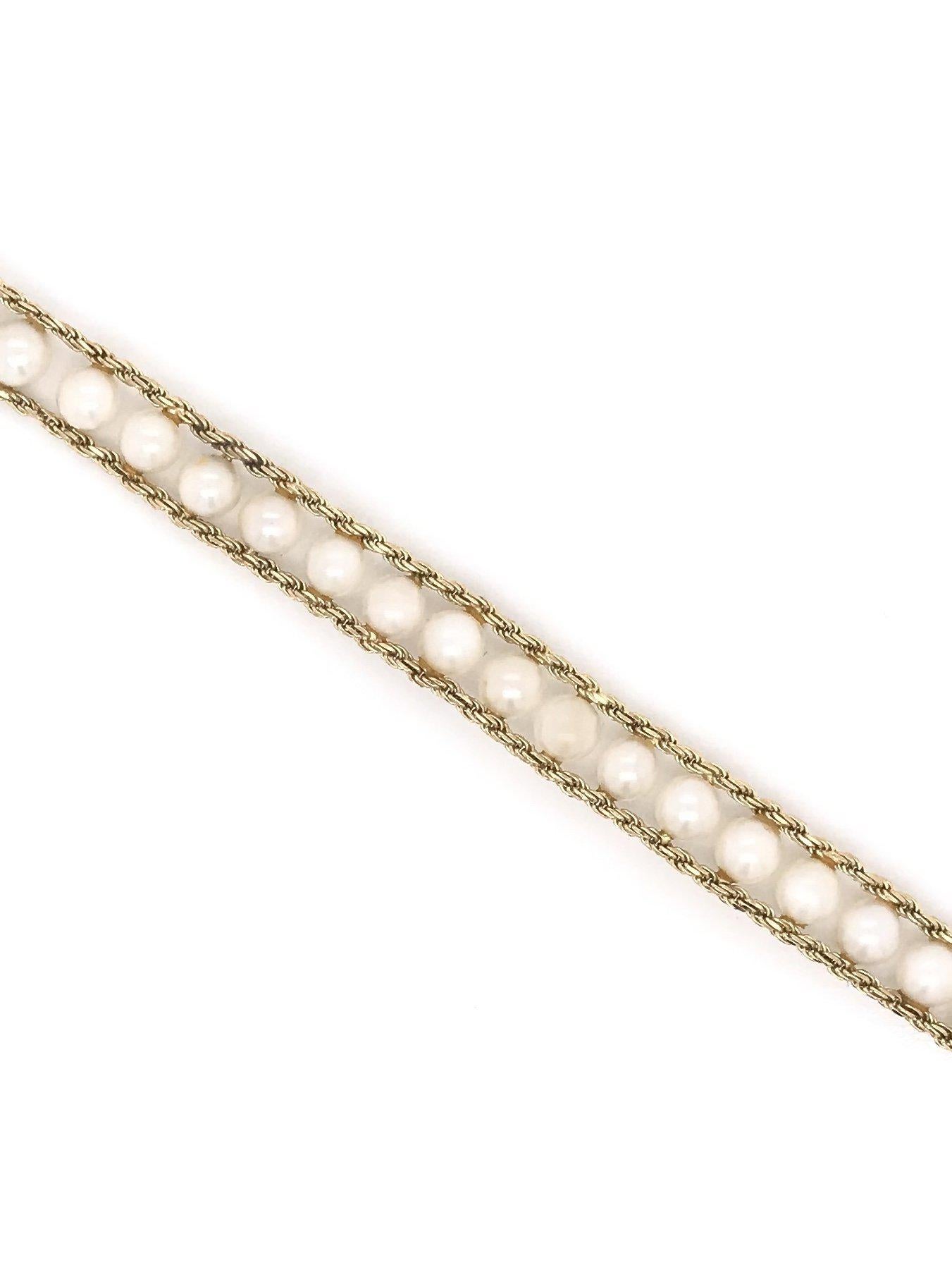 This cultured pearl bracelet was crafted sometime during the Mid Century design period ( 1940-1960 ). This sweet and simple bracelet features 35 small pearls strung between two 14k gold rope chains. The bracelet features an easy to use push button