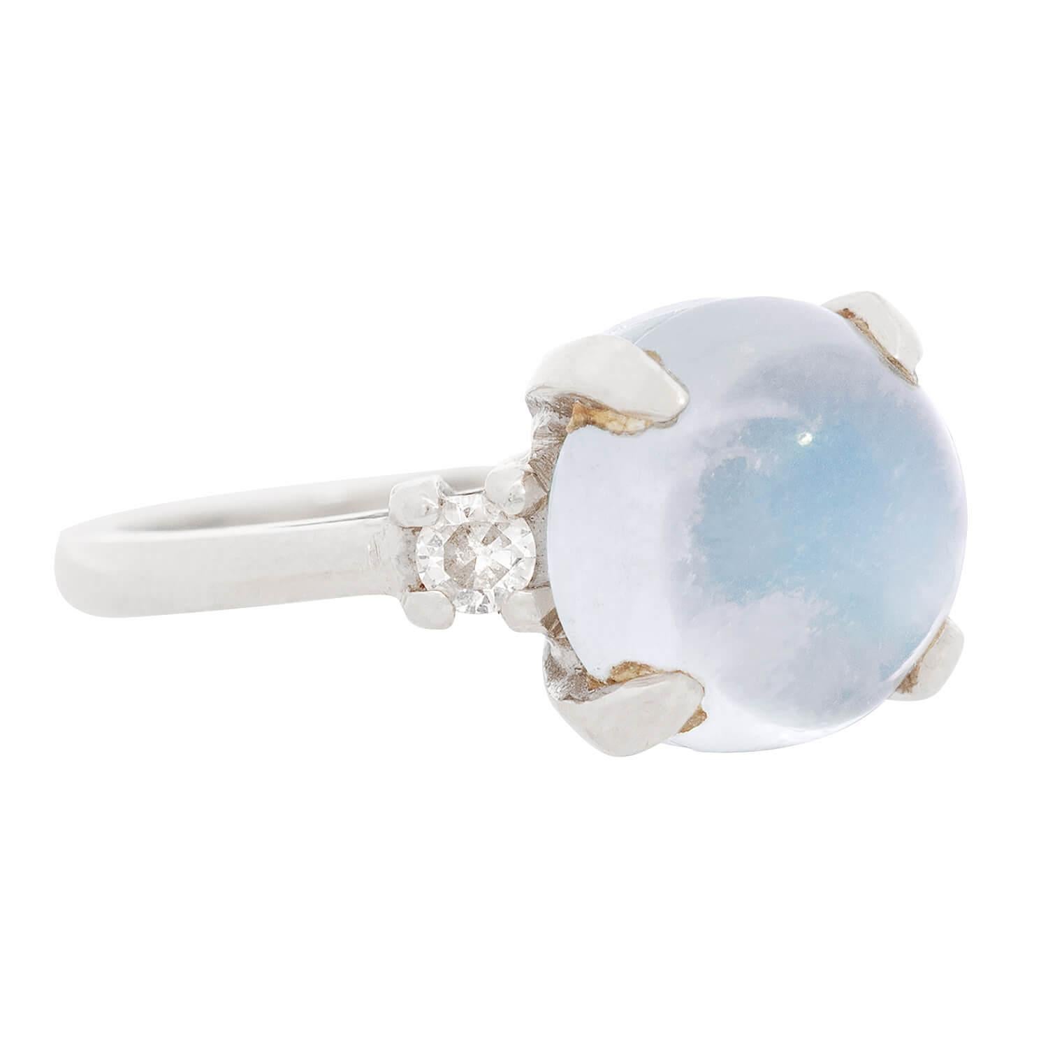 A gorgeous moonstone and diamond ring from the Retro (ca1960s) era! Crafted in 14k white gold, the ring holds a stunning moonstone cabochon at the center of a sleek and stylish mounting. The prong-set moonstone is very alluring, exhibiting a pale