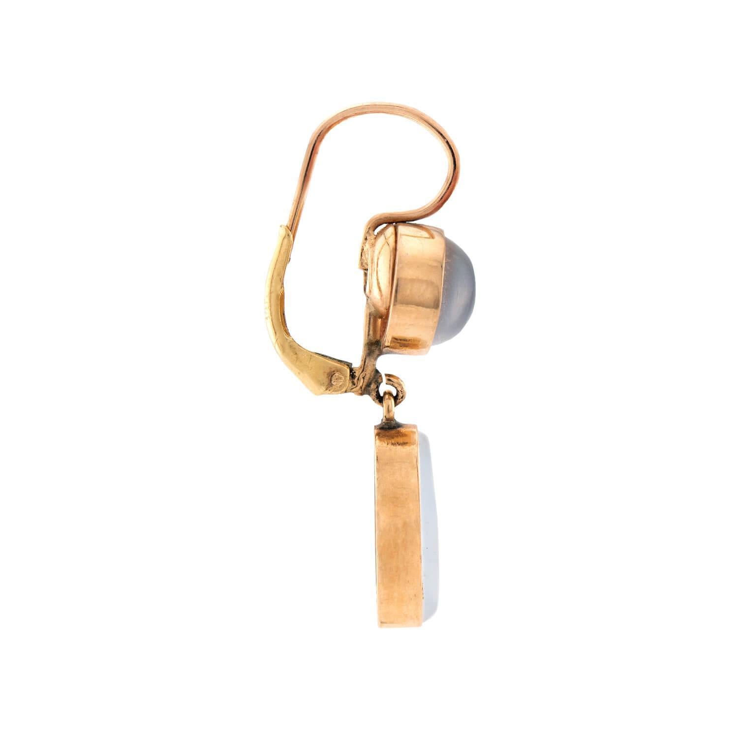 A classically beautiful pair of moonstone earrings from the Retro (ca1950s) era! Crafted in 14k yellow gold, each earring begins with a circular surmount, which features a bezel-set moonstone cabochon. The earrings then feature a lower, larger
