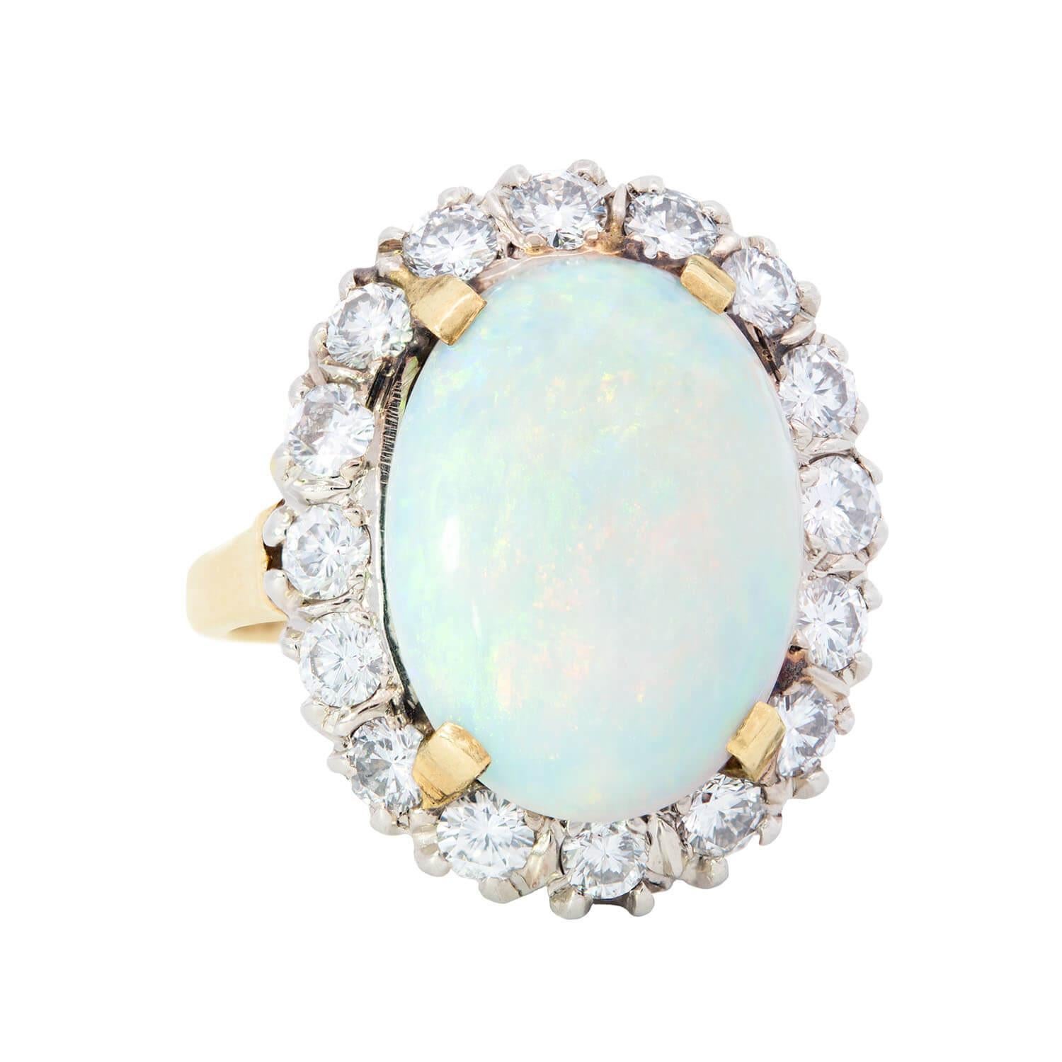 An exquisite opal and diamond ring from the Retro (ca1940) era! This breathtaking ring is made of 14k yellow gold and platinum, and features an alluring prong-set opal cabochon at the center of a sparkling diamond halo. The 5.50ct opal is simply