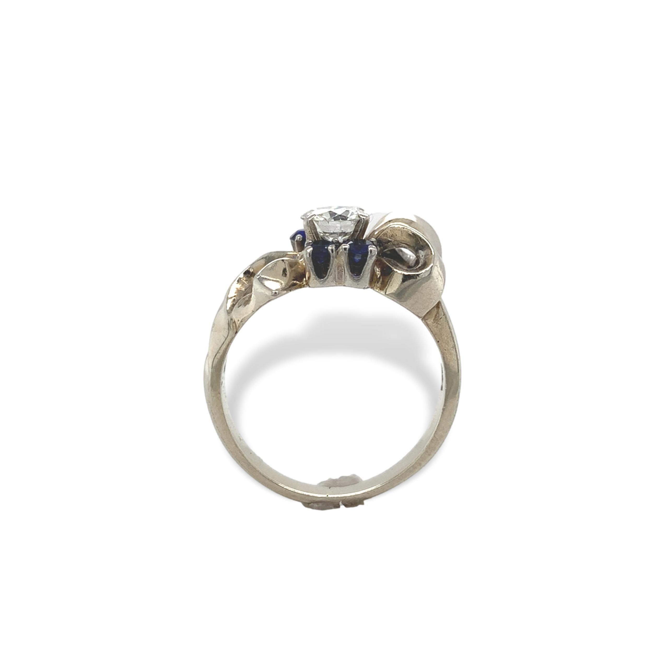 Retro-Diamantring aus 14 Karat Weißgold mit Akzenten aus synthetischen Saphiren.  Der Diamant im europäischen Schliff misst etwa 5,5 mm und wiegt etwa 2/3 ct. Es handelt sich um einen hochwertigen Diamanten mit VS-Reinheit und F-G-Farbe. Es gibt 4