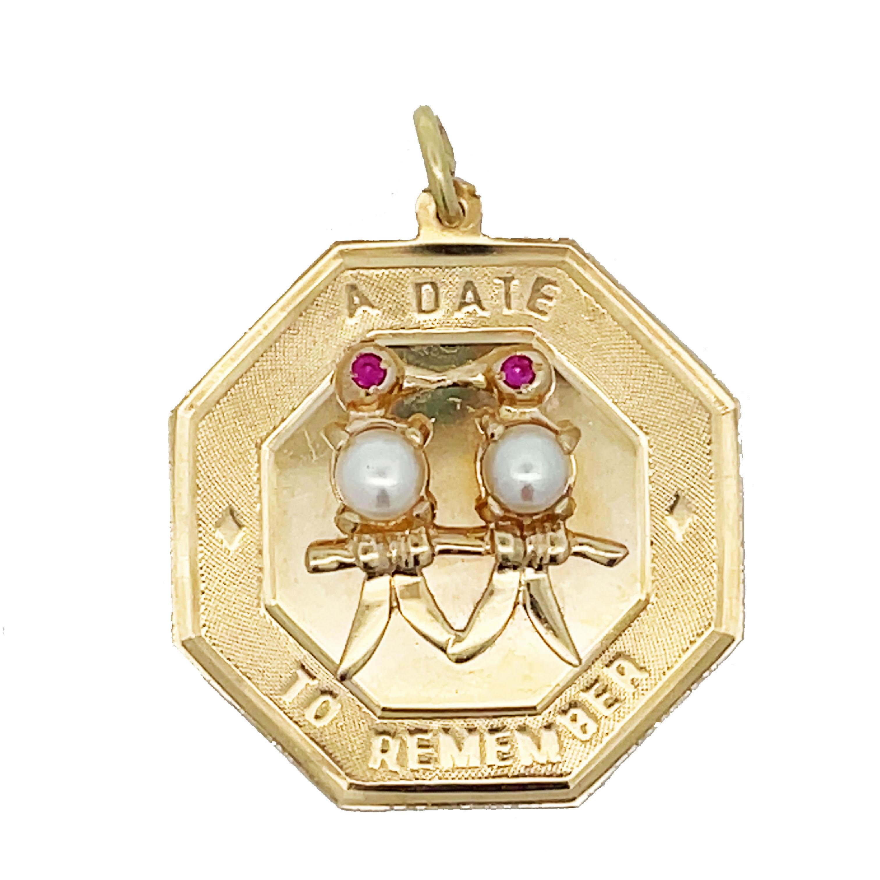 This is a wonderful 1950s pendant adorned with pearls and rubies crafted in 14K yellow gold inscribed with 