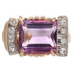 Anillo retro de oro amarillo de 14 quilates con amatista y diamantes. El anillo lleva una esmeralda cu