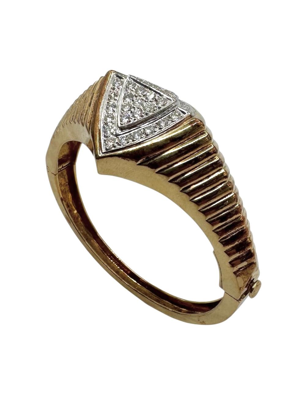 Un bracelet audacieux et élégant de l'ère rétro, fabriqué en or jaune 14 carats, doté d'un design strié qui attire l'attention. La pièce maîtresse est une étonnante plaque géométrique triangulaire sertie d'environ 2,50 carats de diamants ronds