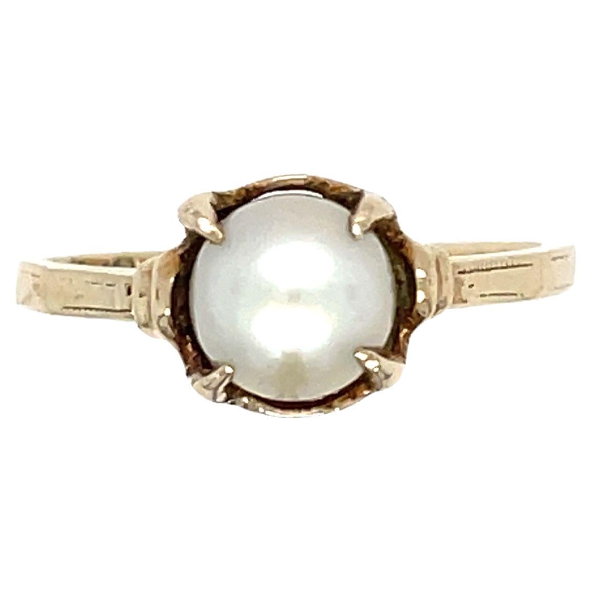 Retro 14K Yellow Gold Cultured Pearl Ring. This elegant ring showcases a single cultured pearl, measuring 6.4 mm in diameter, delicately set in a four-prong setting. The pearl's lustrous beauty is enhanced by the warm glow of the 14K yellow gold