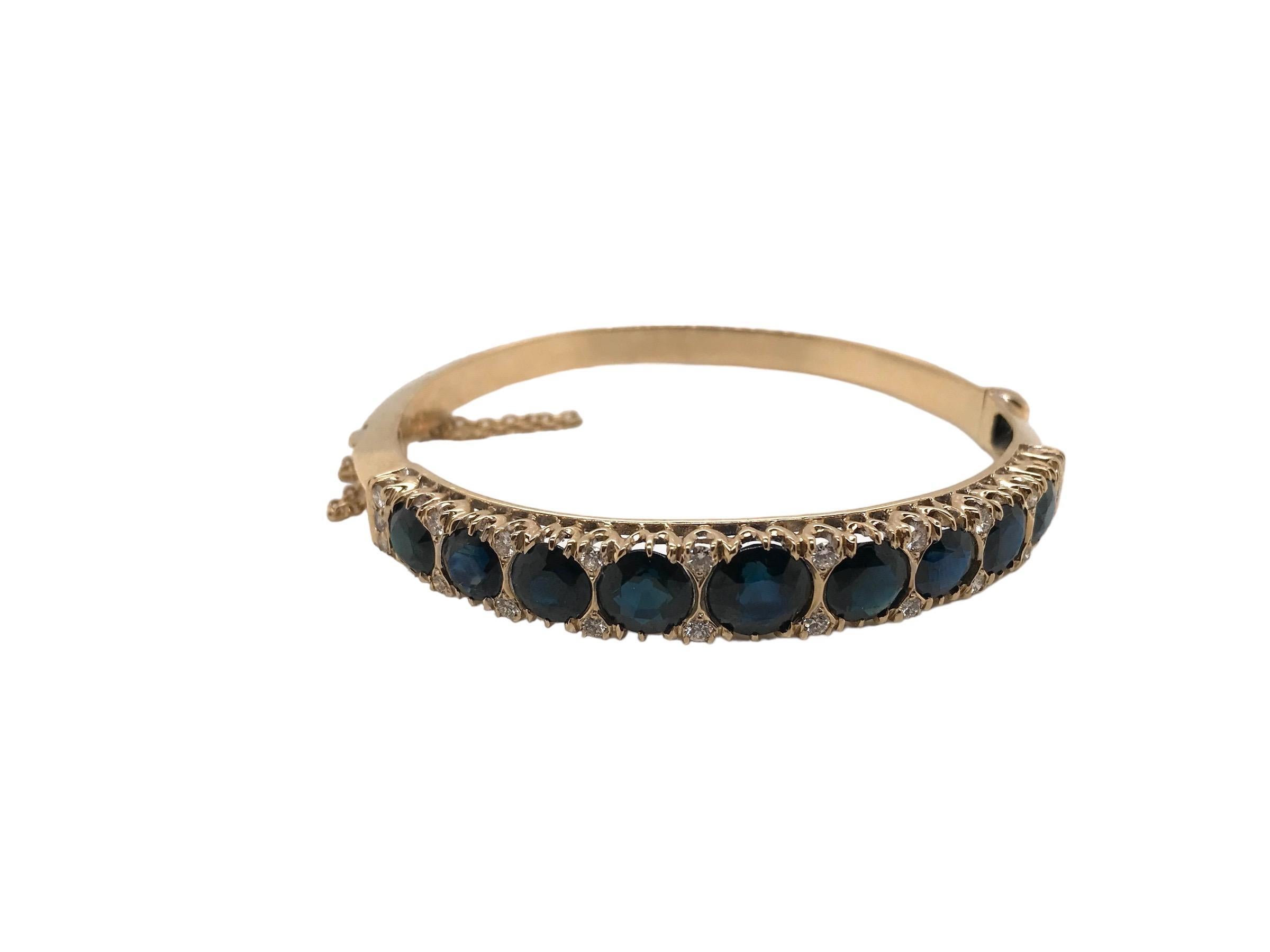 This lovely vintage Retro Era, 1940 - 1960, bangle bracelet is perfection! Set in 14K Yellow Gold and featuring 9 magnificent midnight blue natural sapphire gemstones, weighing approximately 8 Carats combined. Accenting the sapphires are 22