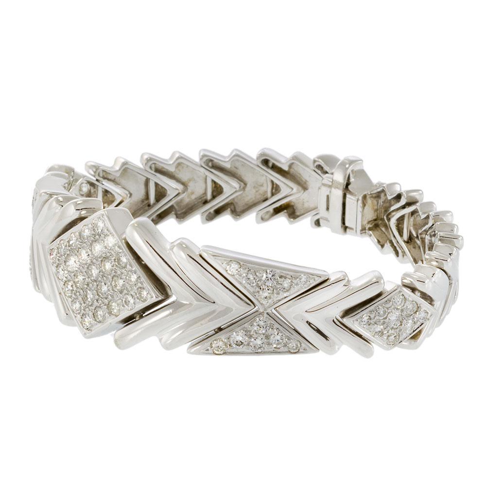 De la época retro, esta atrevida pulsera exhibe un llamativo motivo de chevron engastado con 3,20 quilates de diamantes redondos de talla brillante F-VS. Fabricada en oro blanco de 14 quilates, su diseño de 40 gramos de peso transmite presencia y un