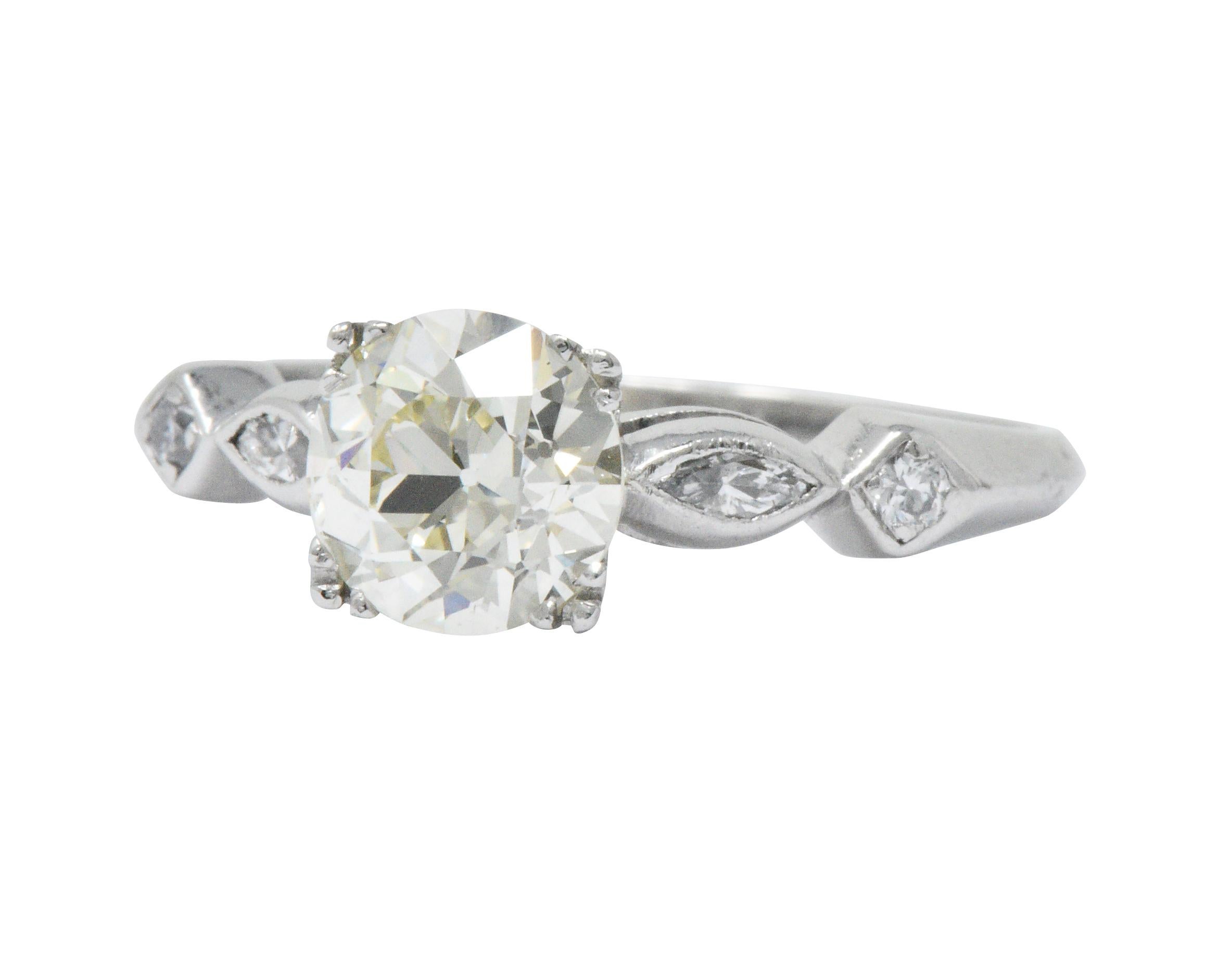 Centering a basket set old European cut diamond weighing 1.49 carats, N color with VS1 clarity

Set by decorative tri-bead prongs in a tapered geometric mounting featuring bezel set diamonds

With marquise and round brilliant cut diamonds weighing