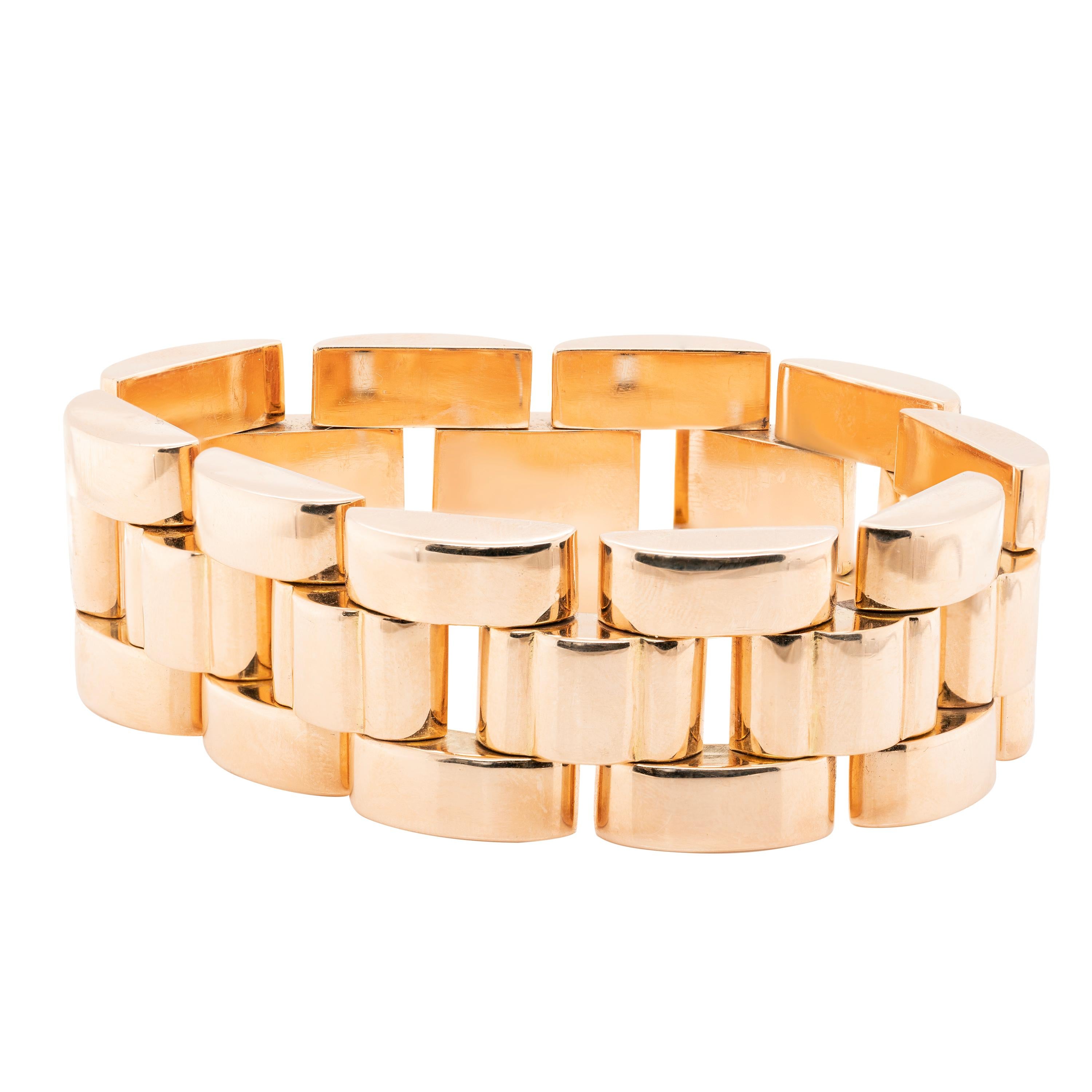 This gorgeous wide bracelet is beautifully designed as an articulated series of high polish 18 carat yellow gold convex links and secures with a box clasp. Tank bracelets, popular in the 20th Century, are so called because their links resemble tank