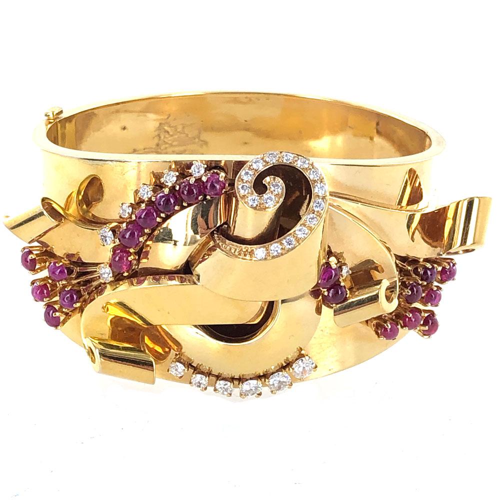This stunning Retro wide bangle bracelet is fashioned in 18 karat yellow gold. The design features 2.00 carat total weight of round brilliant cut diamonds graded F-G color and VS clarity. The bracelet also is crafted with  cabochon red ruby