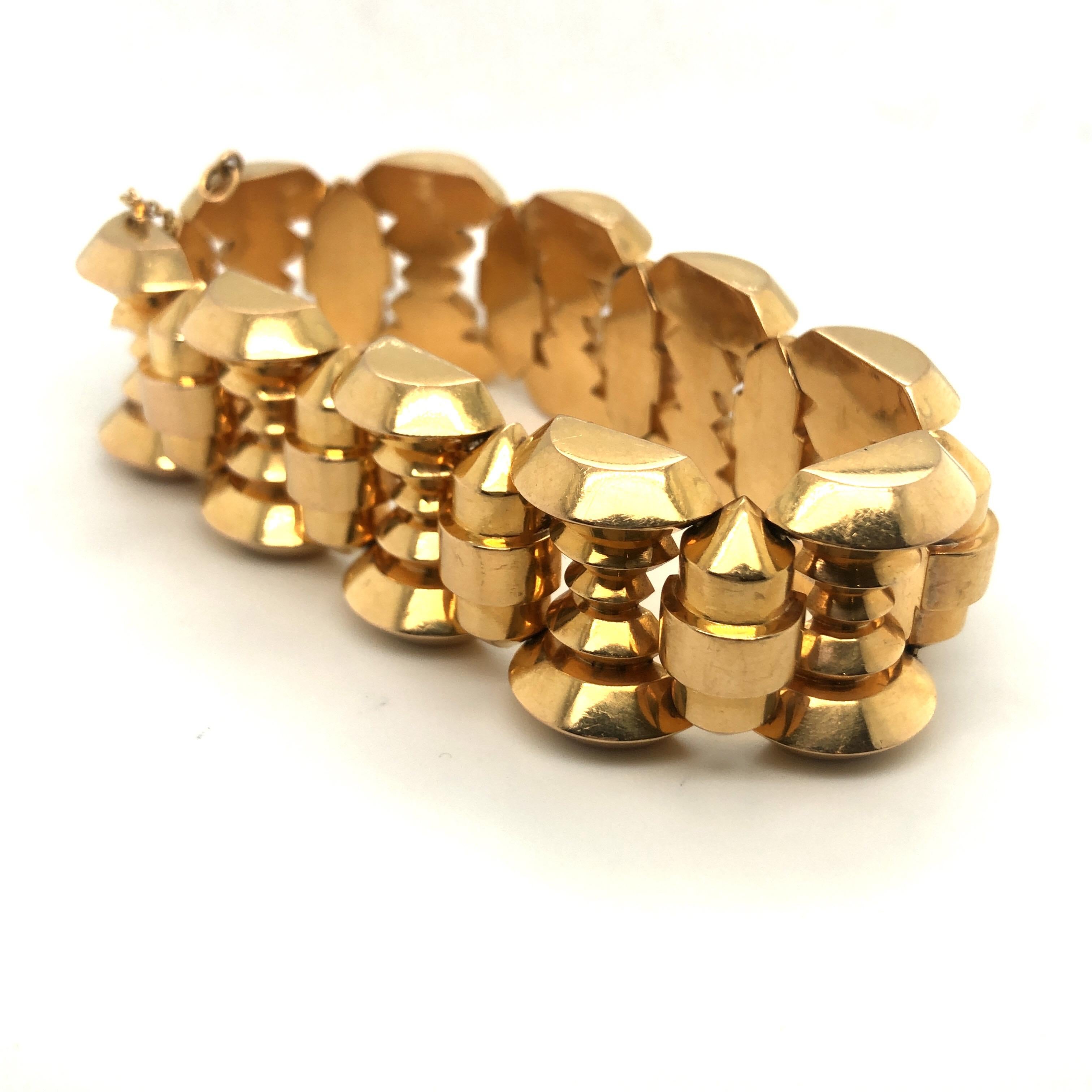 Retro 18 karat rose gold tank bracelet from the 1940s.
A bold and stylish retro bracelet designed as a wide band of 18 karat rose gold geometric domed links, beautifully articulated and slithering on the hand. The workmanship is of a high standard.
