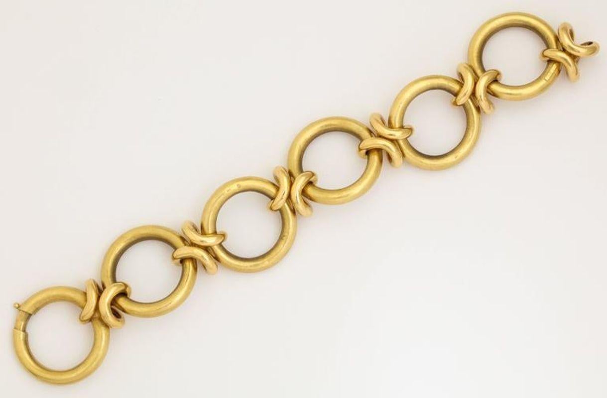 A great 18K Gold Circle Link Bracelet with love knots connecting the open circles. signed. The links have a textured matte finish. This is a day wearable, never take off piece of jewelry.

