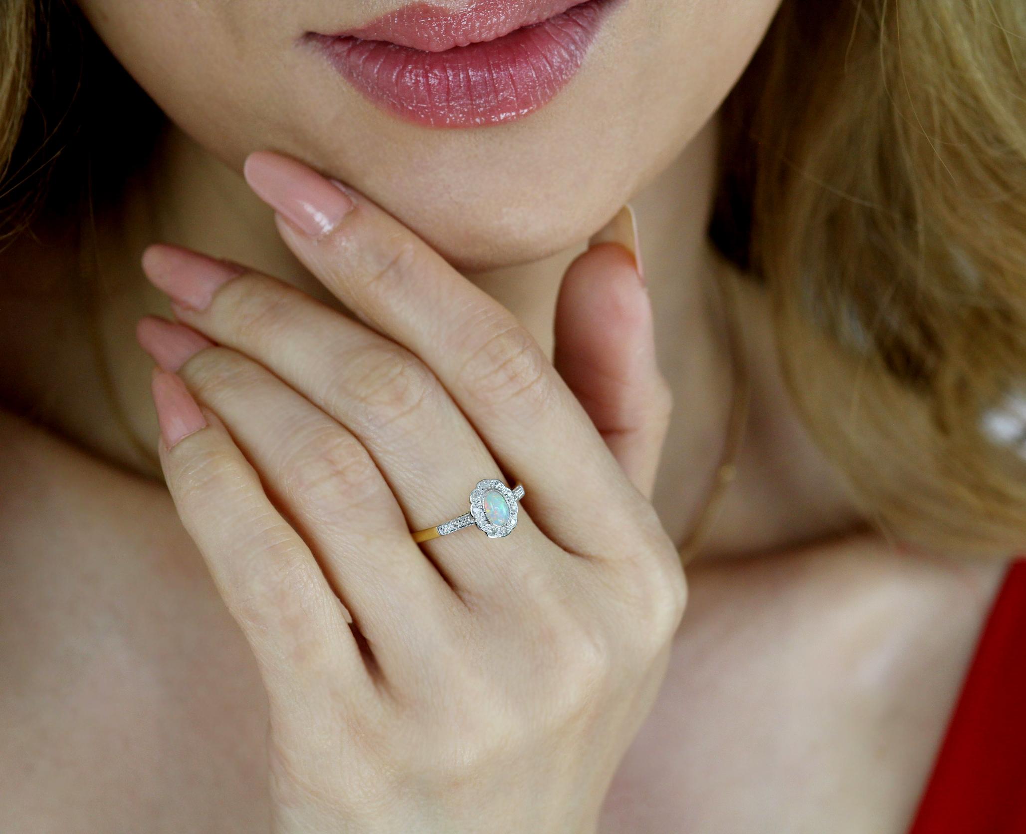 Zierlicher Ring aus 18-karätigem Gold und Platin mit einem ovalen weißen Opal in der Mitte, umgeben von 0,35-karätigen runden Diamanten im Einzelschliff mit Millgraining an den Rändern der Fassung.

12 Diamanten im Einzelschliff, ungefähres