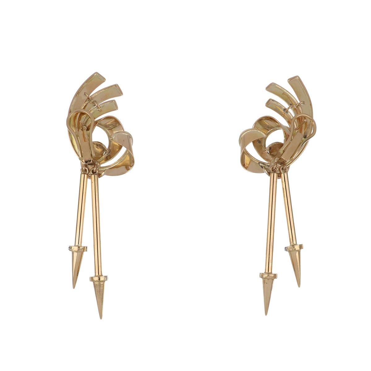 Retro 18K rose gold swirl motif earrings with double arrow drops and diamonds set in white gold. The earrings are set with 22 single-cut diamonds totaling 0.30 carats, J-K color, SI1-SI2 clarity. They are 3 1/2 inches in length. Circa 1940. 
