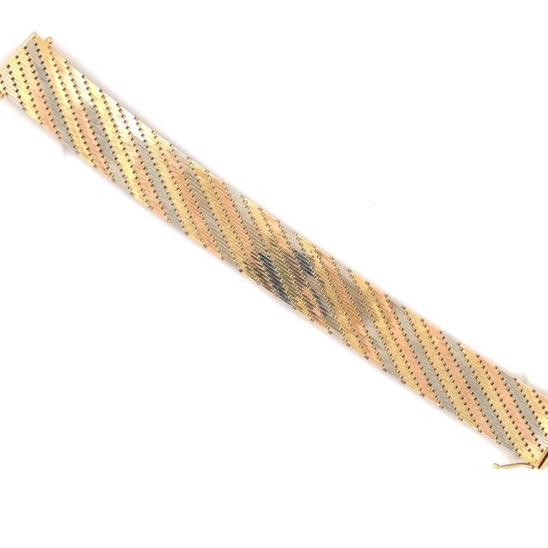 Un bracelet Retro en or tricolore 18K avec une finition polie mesurant 18 millimètres de large et 7,25 pouces de long. Avec double fermoir de sécurité en forme de 8. Vers les années 1940.

Brillant, ensoleillé, substantiel.

Informations