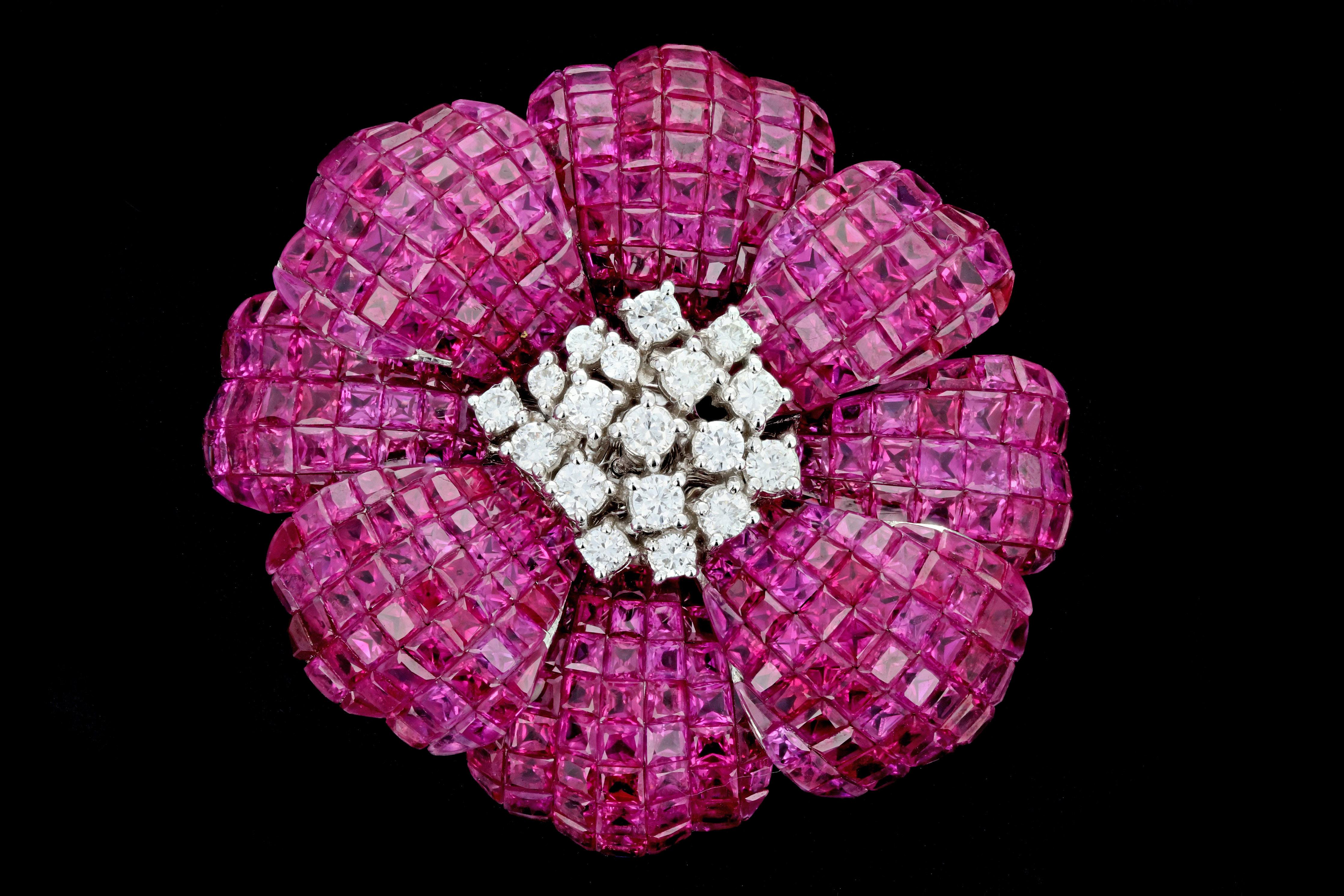 Era: Retro

Composition: 18K White Gold

Primary Stone: Square Step Cut Rubies

Carat Weight: 25 Carats

Accent Stone: Round Brilliant Cut Diamonds

Carat Weight: 1 Carat

Color: G-H

Clarity: VS1/2

Total Carat Weight: 26 Carats

Brooch Weight:
