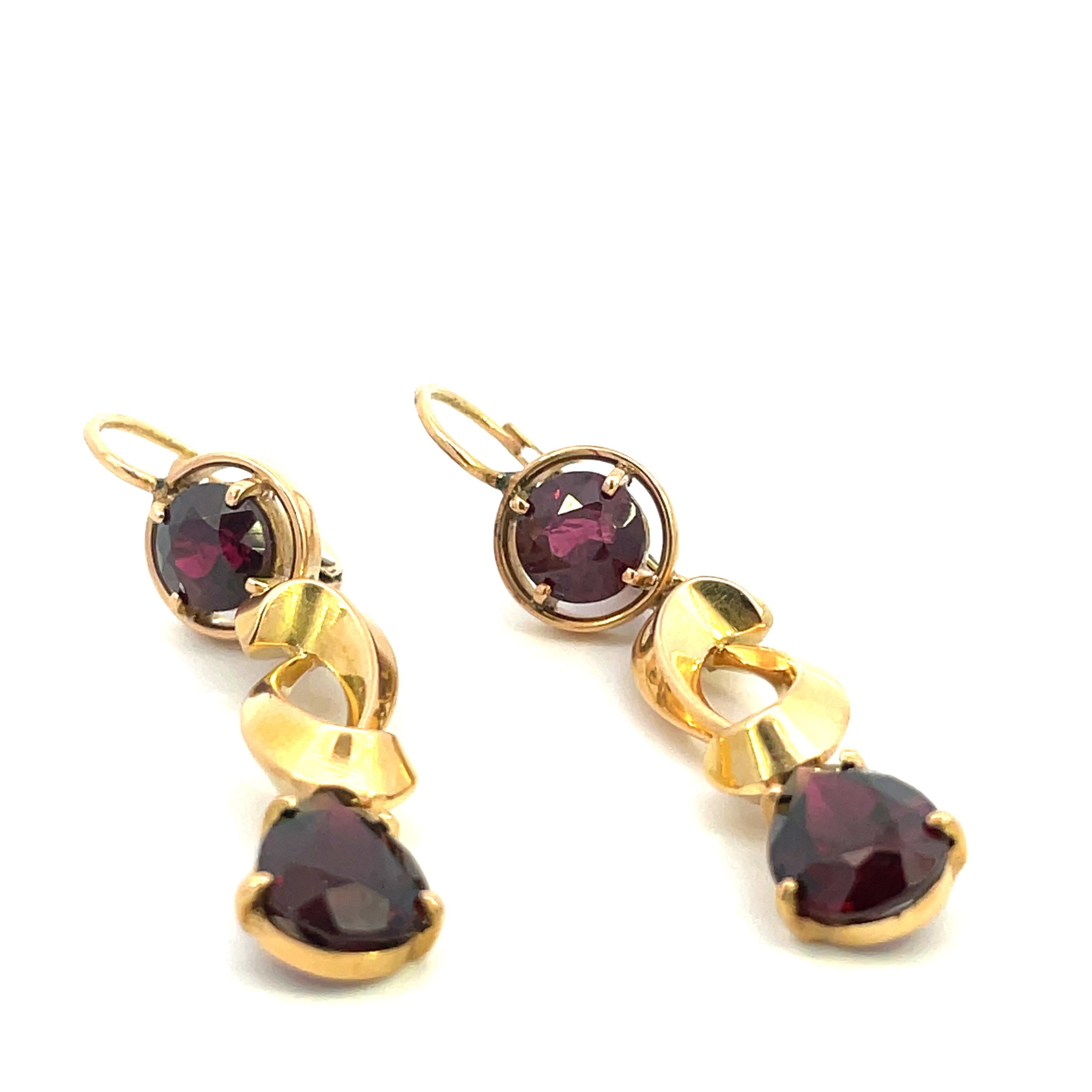 - 18K Yellow Gold 
- 2 = 1.10 TW Round Cut Garnet 
- 2 = 2.24 Tw Pear Cut Garnet 
- 7 CTTW 
- 7.10 Grams 

This is a stunning pair of retro drop earrings made in 18k yellow gold with garnet. Each earring contains a 1.10 twt round cut garnet stud at