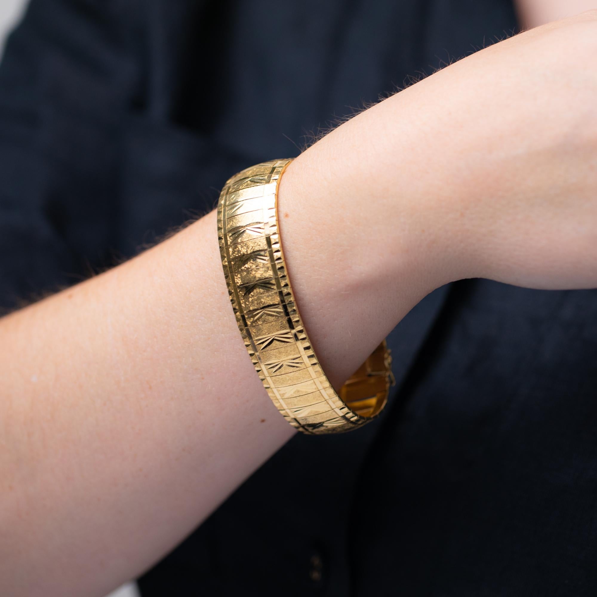 Ce bracelet en or jaune du milieu du XXe siècle présente des gravures en forme de diamant et des maillons texturés. Sécurisé par un fermoir caché et équipé de deux clips de sécurité en forme de huit. Poinçonné et estampillé BREV, 50319VI, F.O.R 750