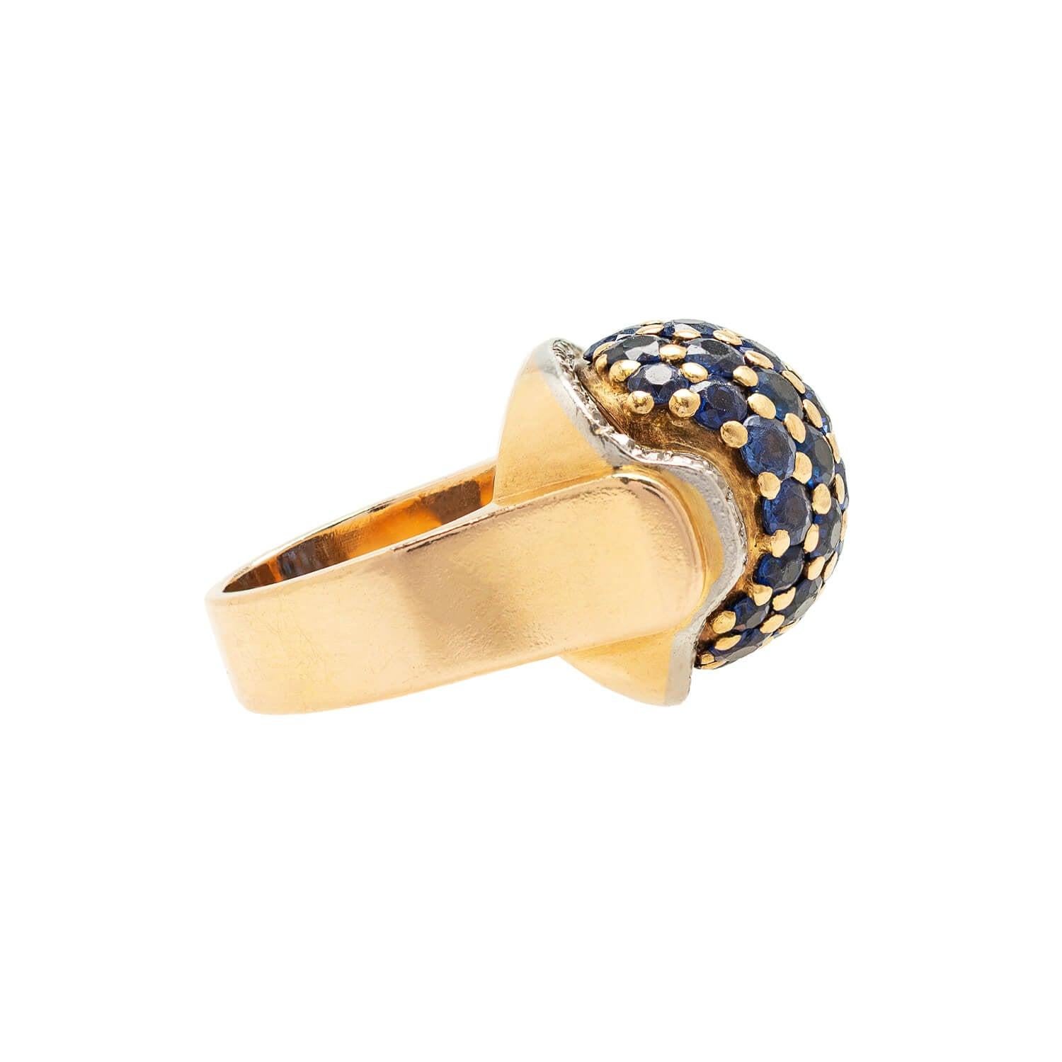 A fabulous bombé style ring from the Retro (ca1940s) era! Crafted in 18kt white and yellow gold, this fabulous piece has a classic Retro appeal and features sapphires and diamonds, all set within a dual-tone gold setting. Beautiful rich blue