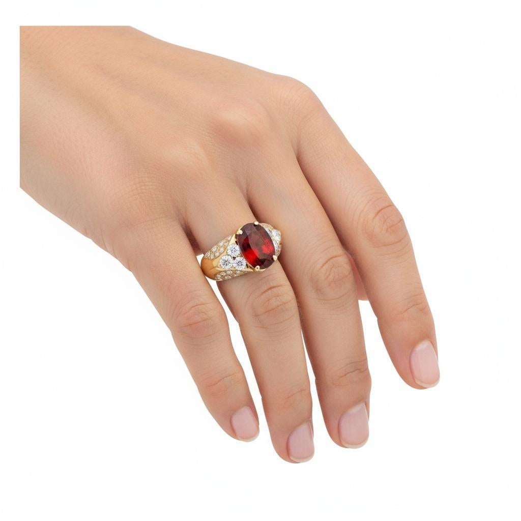 Questo anello retrò in oro giallo 18kt sfoggia un classico stile vintage, con al centro un granato naturale di forma ovale di circa 2,45 carati, che mostra una tonalità ricca e calda che si integra perfettamente con l'oro. La pietra centrale è