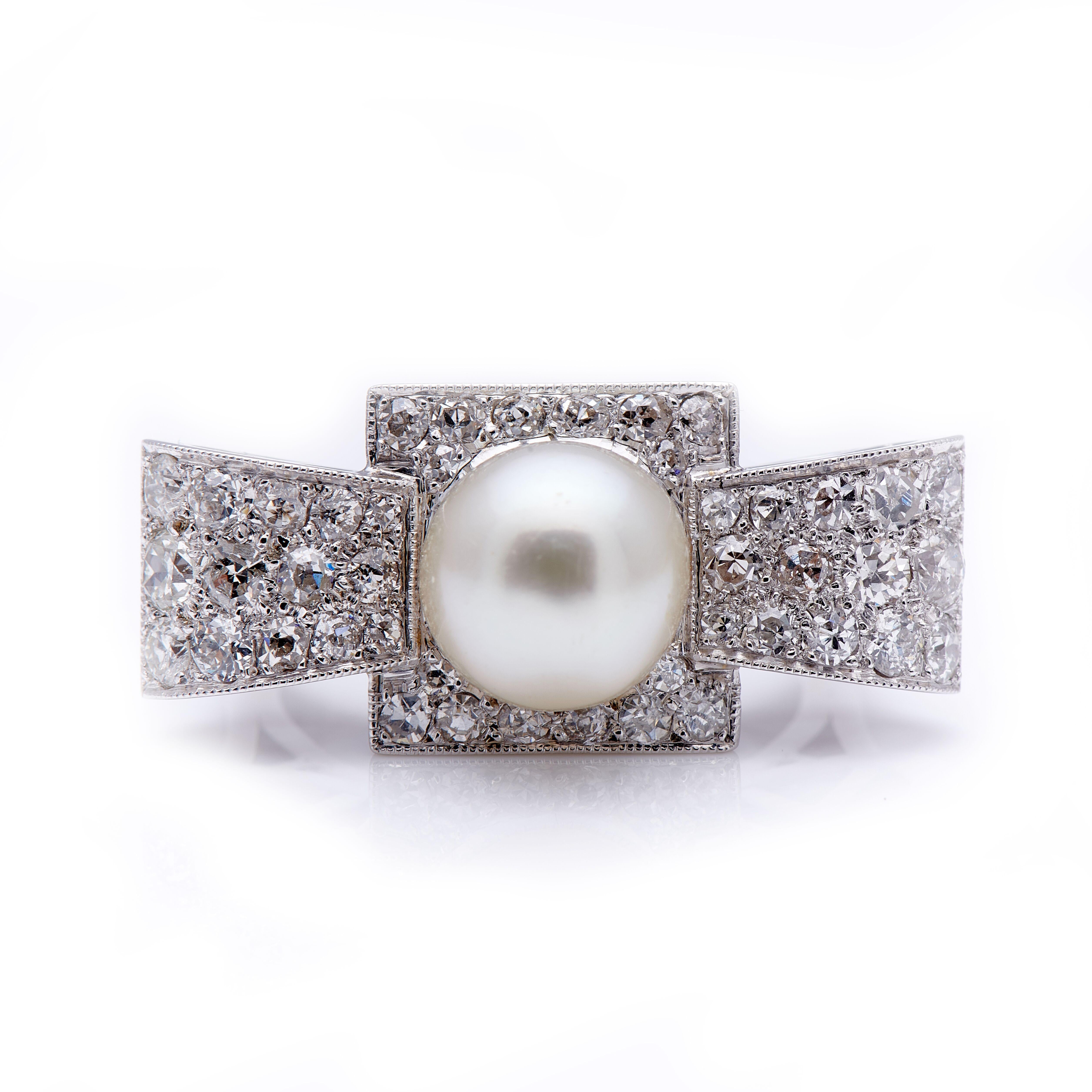 Art Deco, pearl and diamond cocktail ring, circa 1930. A hugely impressive ring, set with a single lustrous white pearl in the centre of a wonderful diamond set bow-like design. This ring is not for the faint-hearted, its size equals its beauty. The