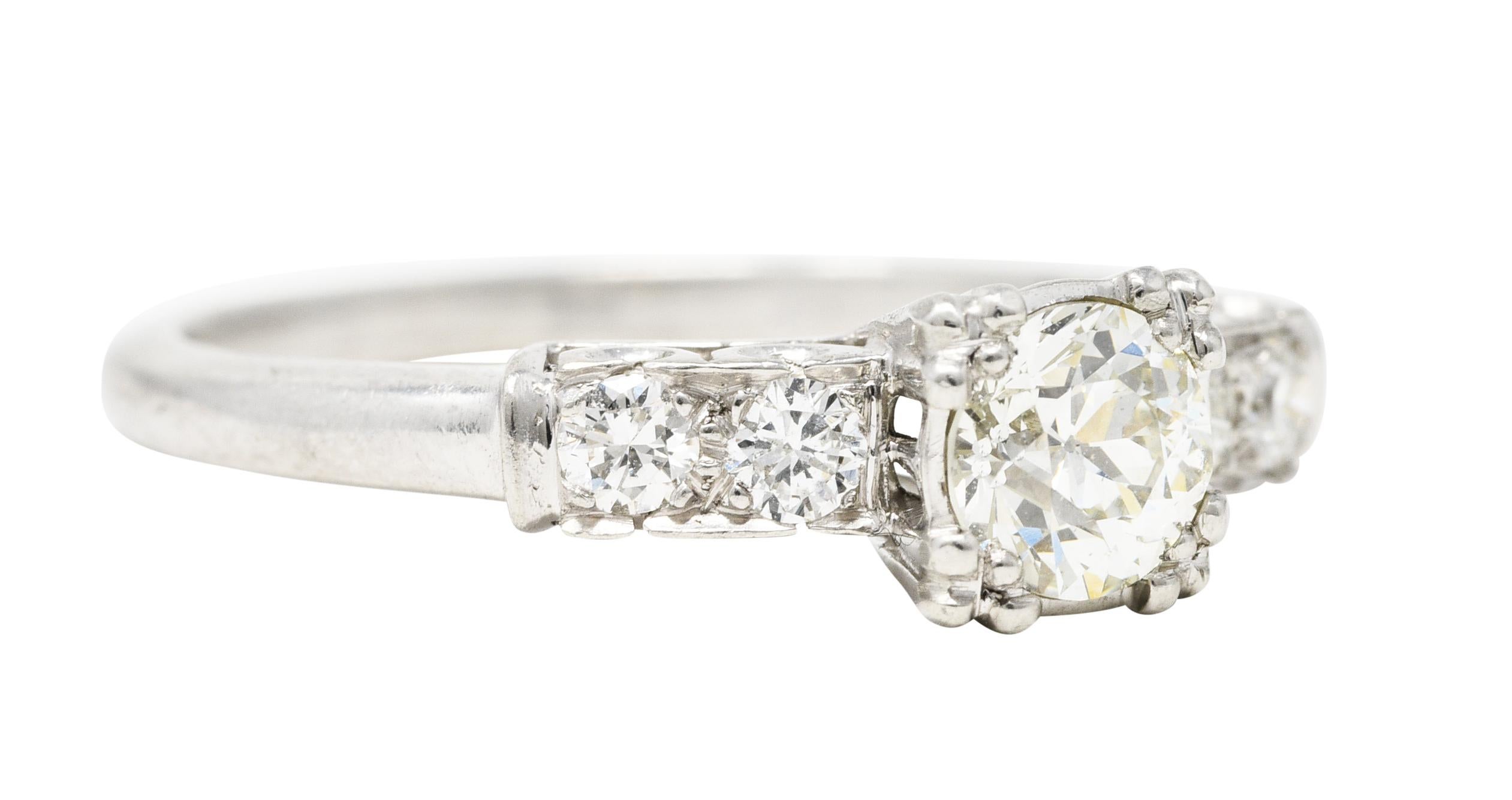 Centering an old European cut diamond weighing approximately 0.53 carat total - J color with VS2 clarity. Prong set by tri-split prong with a pierced gallery and flanked by bead set old European cut diamonds. Weighing approximately 0.24 carat total