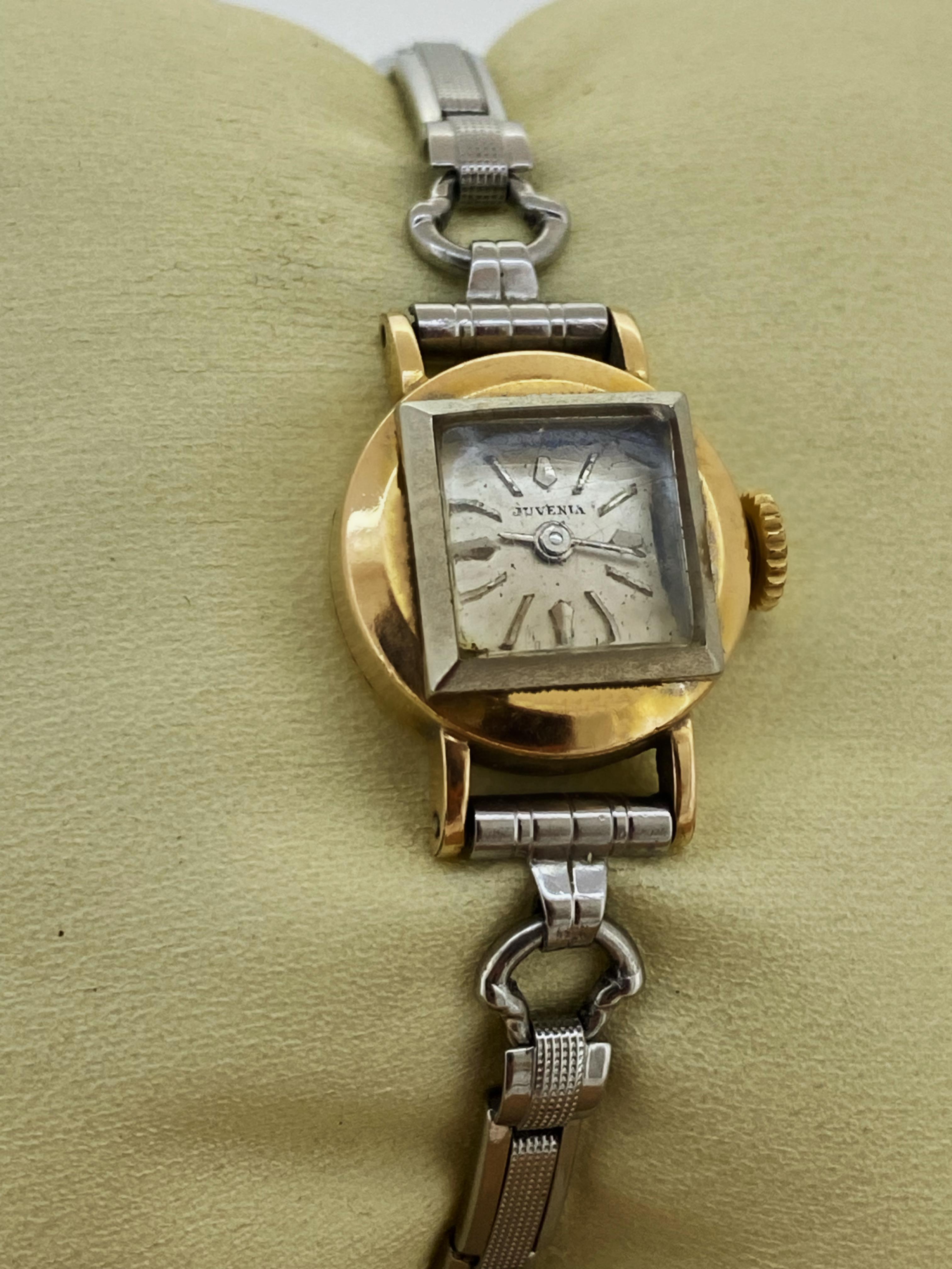 This Fine Retro circa 1940’s timepiece 
by Juvenia features: 

Round 17mm gold-filled CASE  

Swiss Manual (hand-winding) MOVEMENT – 
Signed & numbered

Under a square shaped glass 
an unusual square silver-coloured DIAL 
features Baton numerals &