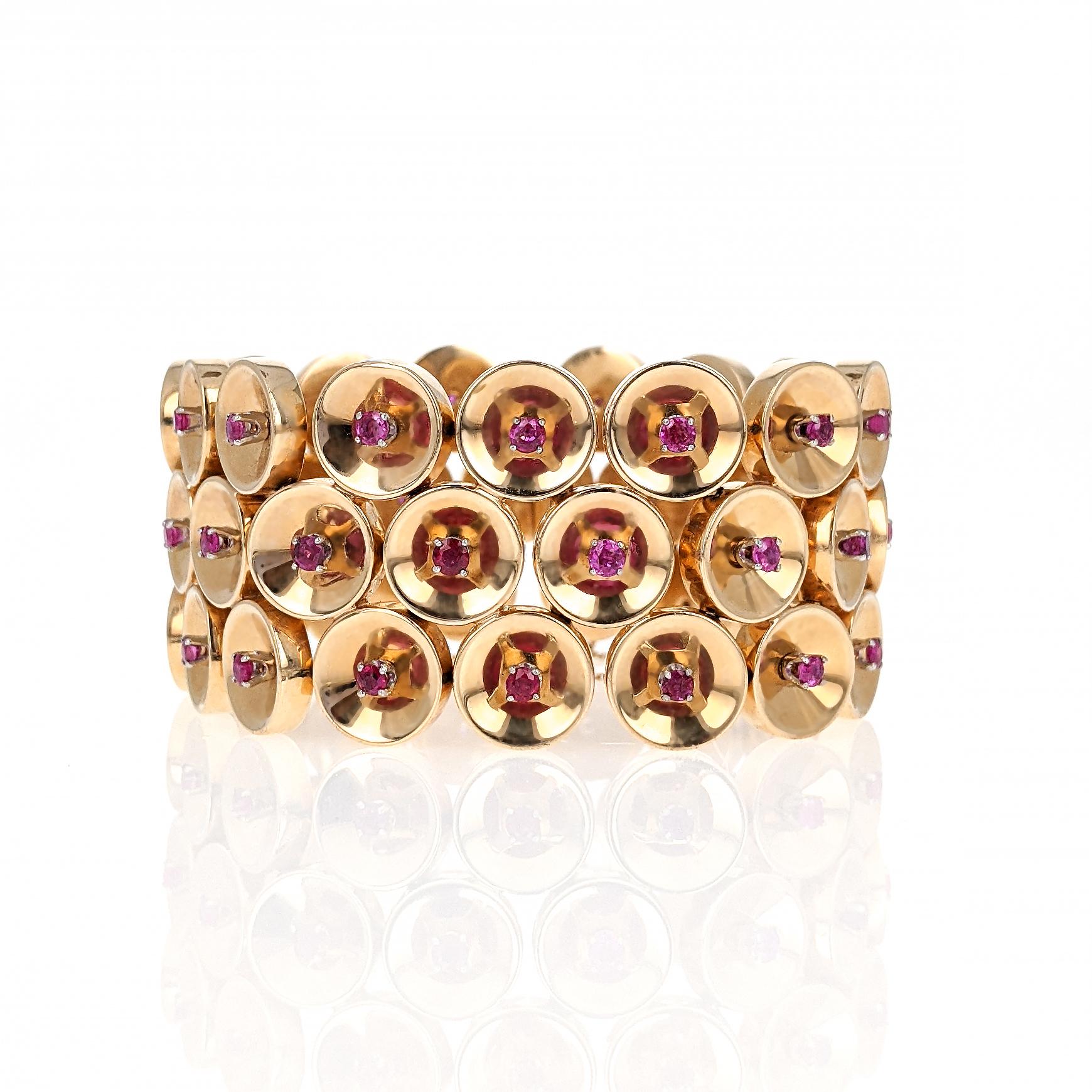 This Retro 1940s bracelet is designed as three rows of connecting disc links, each centering on a round-cut ruby. The discs are concave and create a cool optical effect by reflecting the ruby and prong setting.   The links are well constructed,